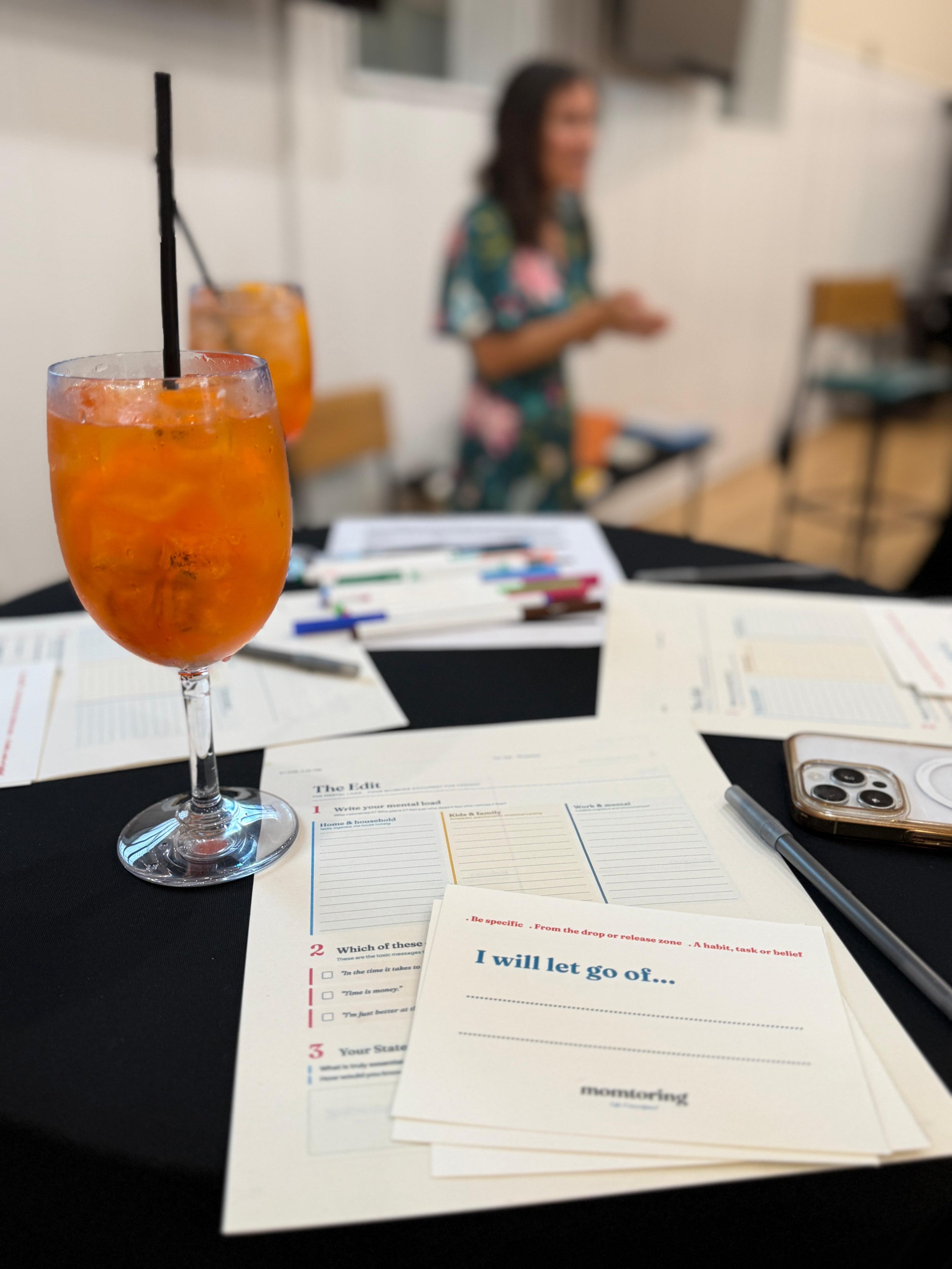 A focused, atmospheric view of printed workshop worksheets and pens laid out on a table for attendees.