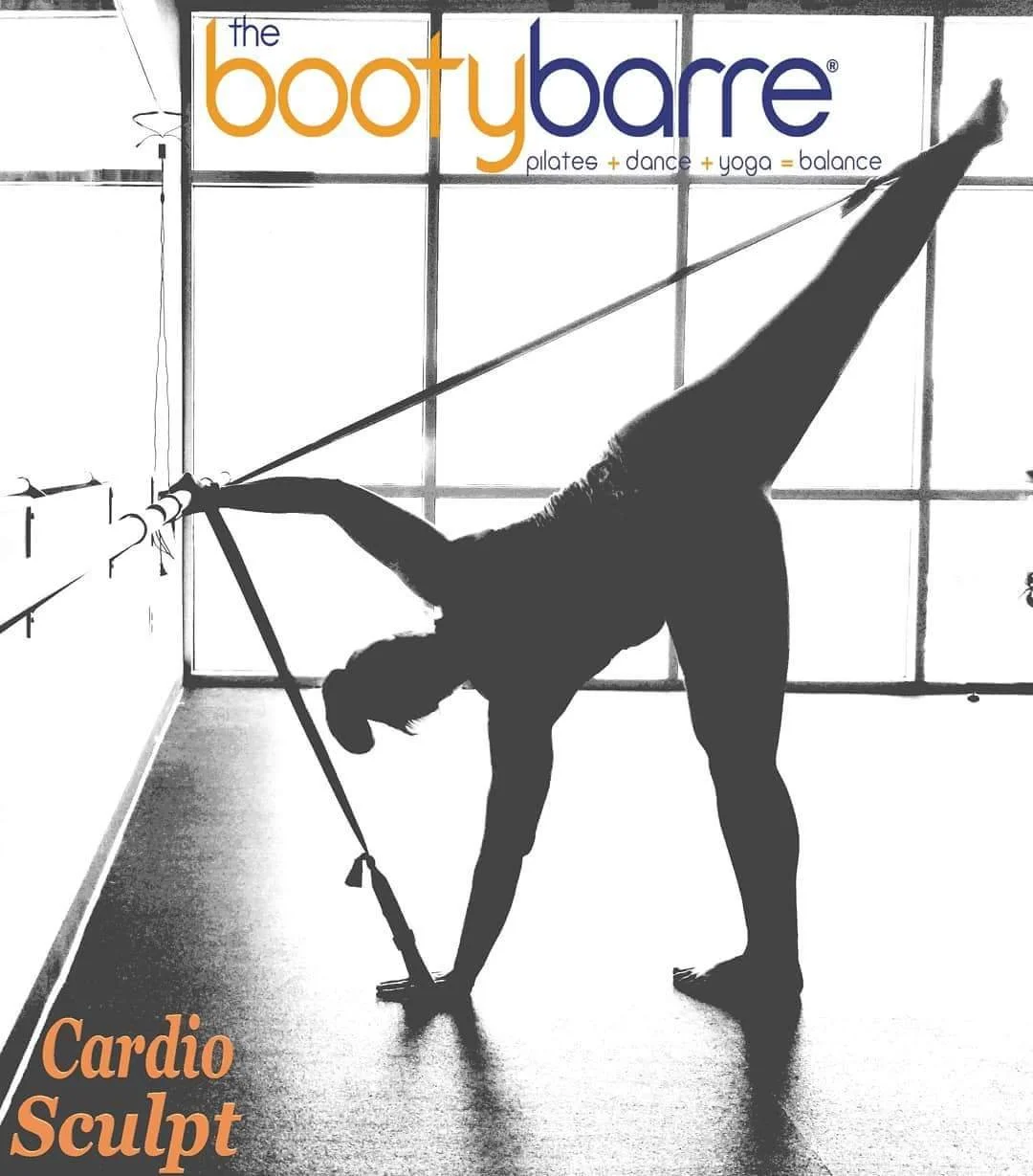 Bella at the barre in "Star" position. She is has her left hand on the floor in a cuff which is tied to the barre. Her left leg is up in the air, cuff strapped to her foot. Her right hand is on the barre.