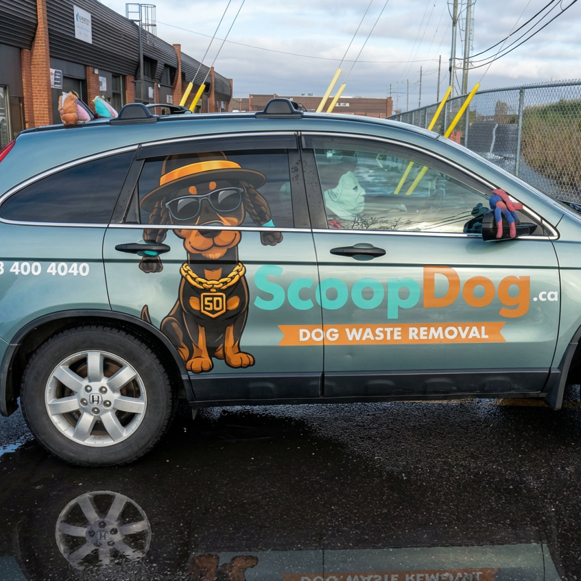 A parked vehicle with ScoopDog.ca branding, featuring a cartoon dog wearing sunglasses, a hat, and a gold chain, advertising dog waste removal services.