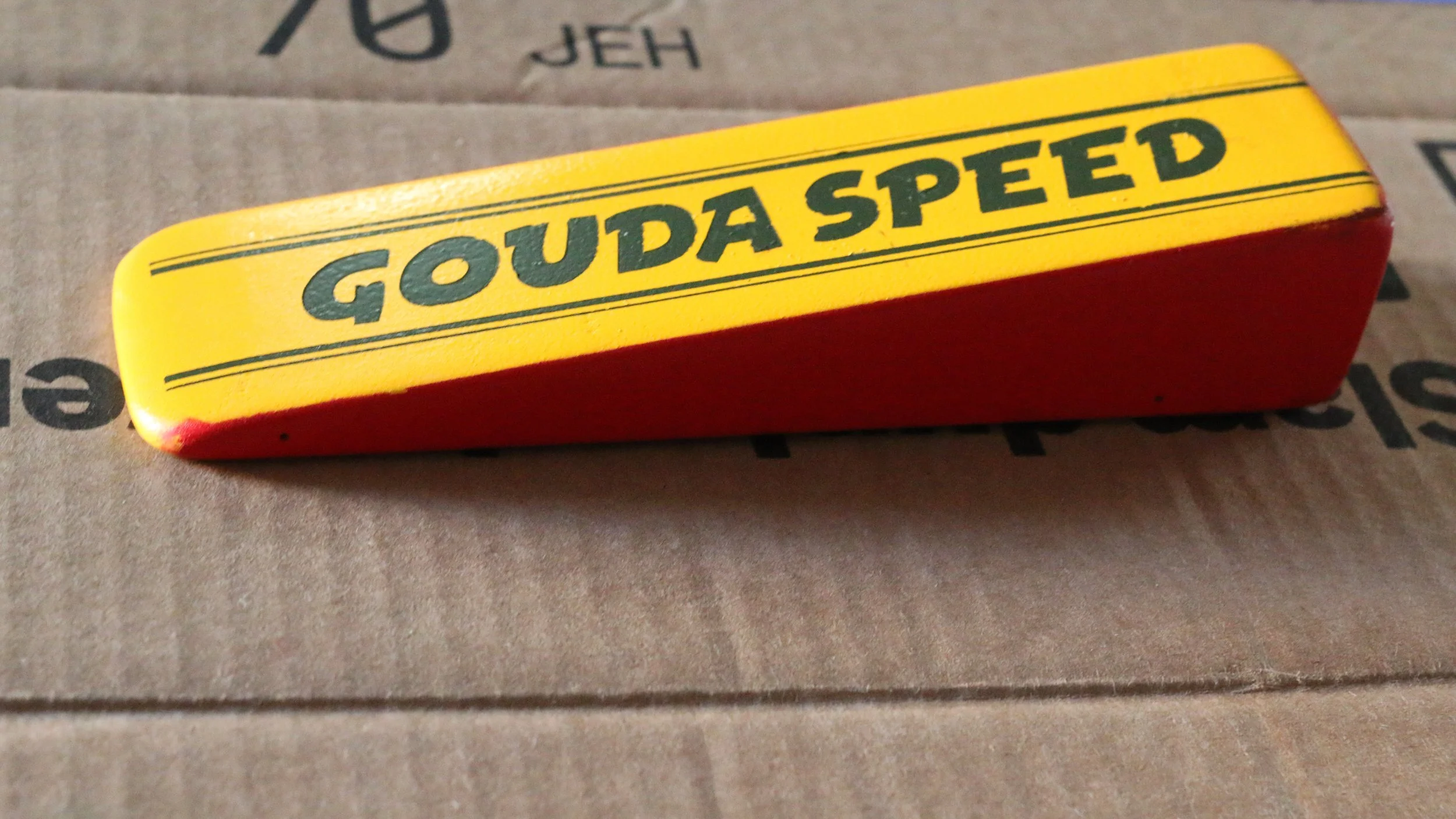 Official pinewood derby car cut into a wedgeshape. The car is painted like a chunk of cheese