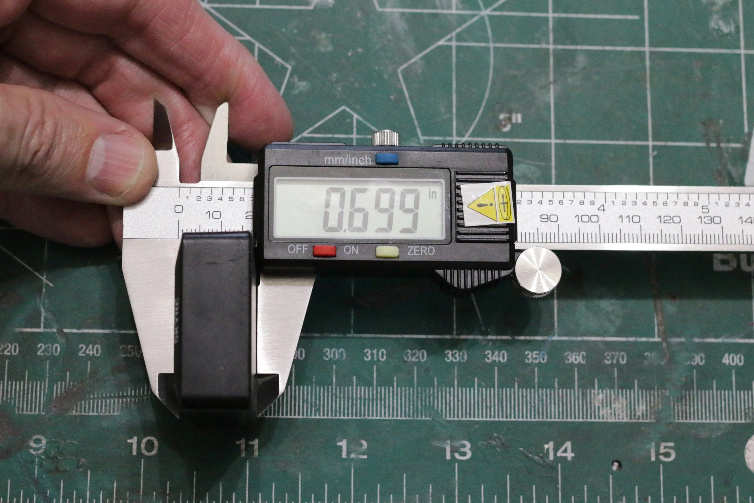 Sky RC width being measured by a caliper.  This is the SKY RC GNSS unit with width of .699 inches