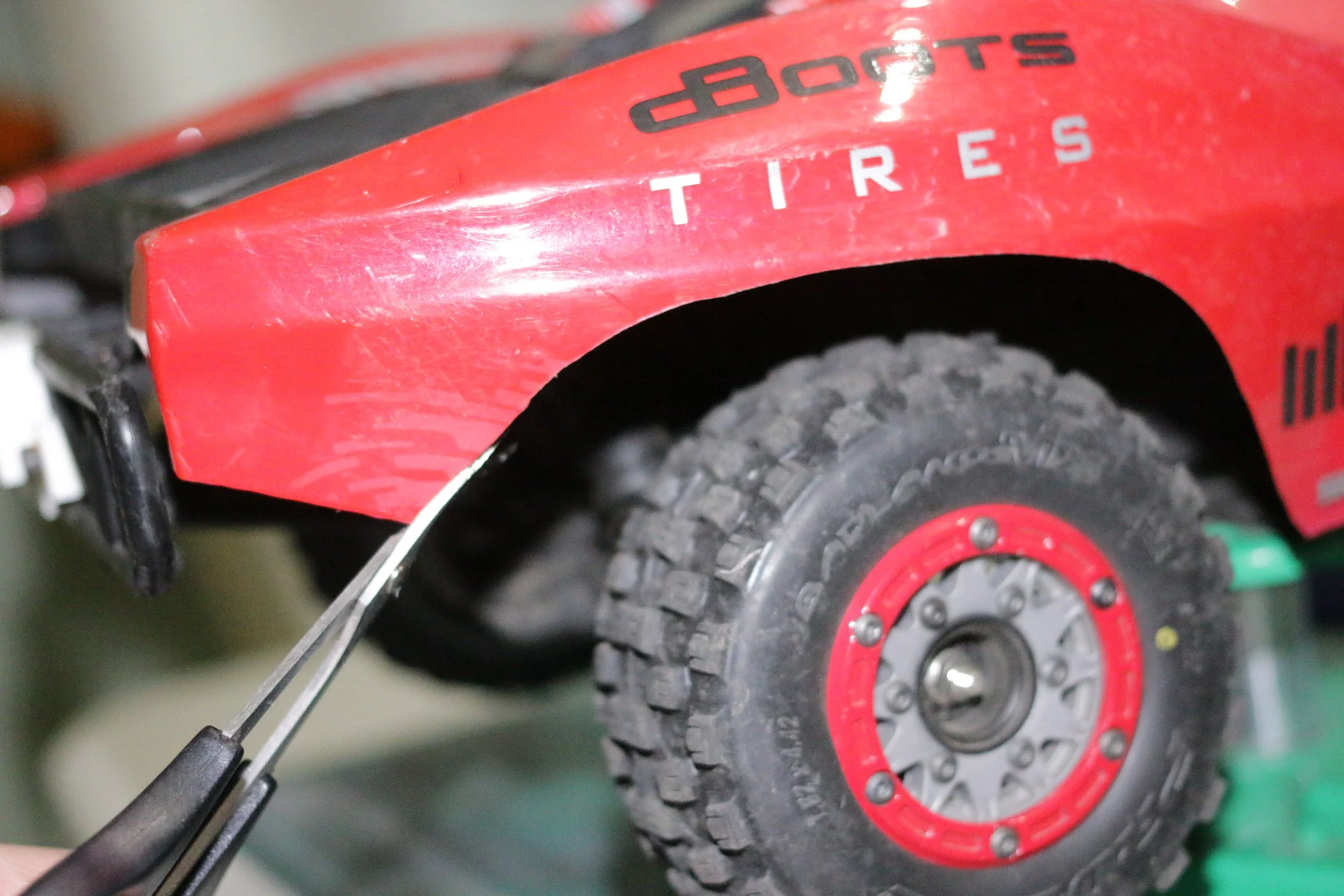 Red Arrma Fury with trimmed fender fitted with ProLine Badlands tires