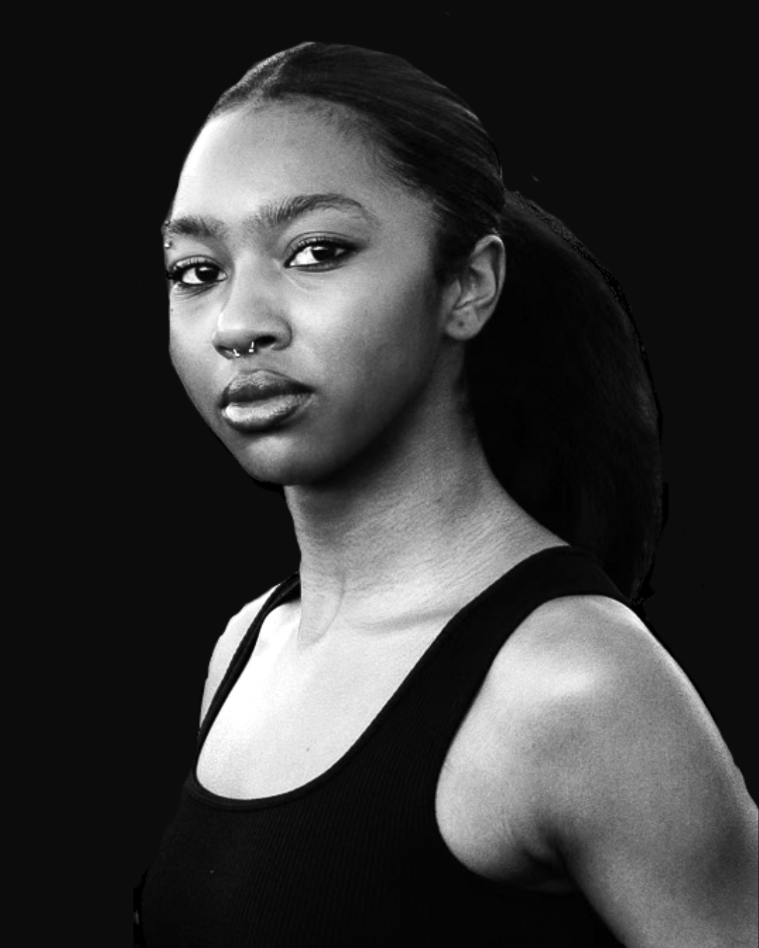 Black and white portrait of a person with long hair tied back, wearing a tank top and a nose piercing.