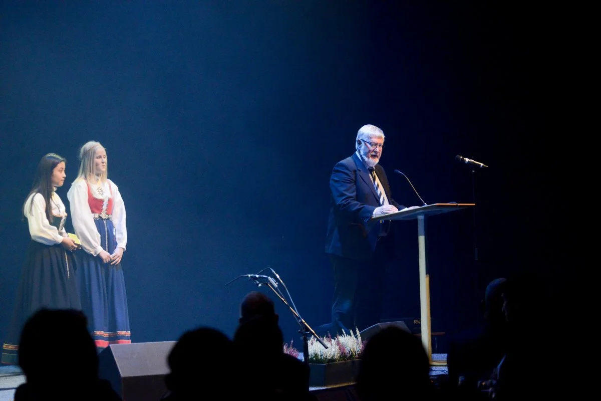 Taler holder tale foran publikum under jubileums event