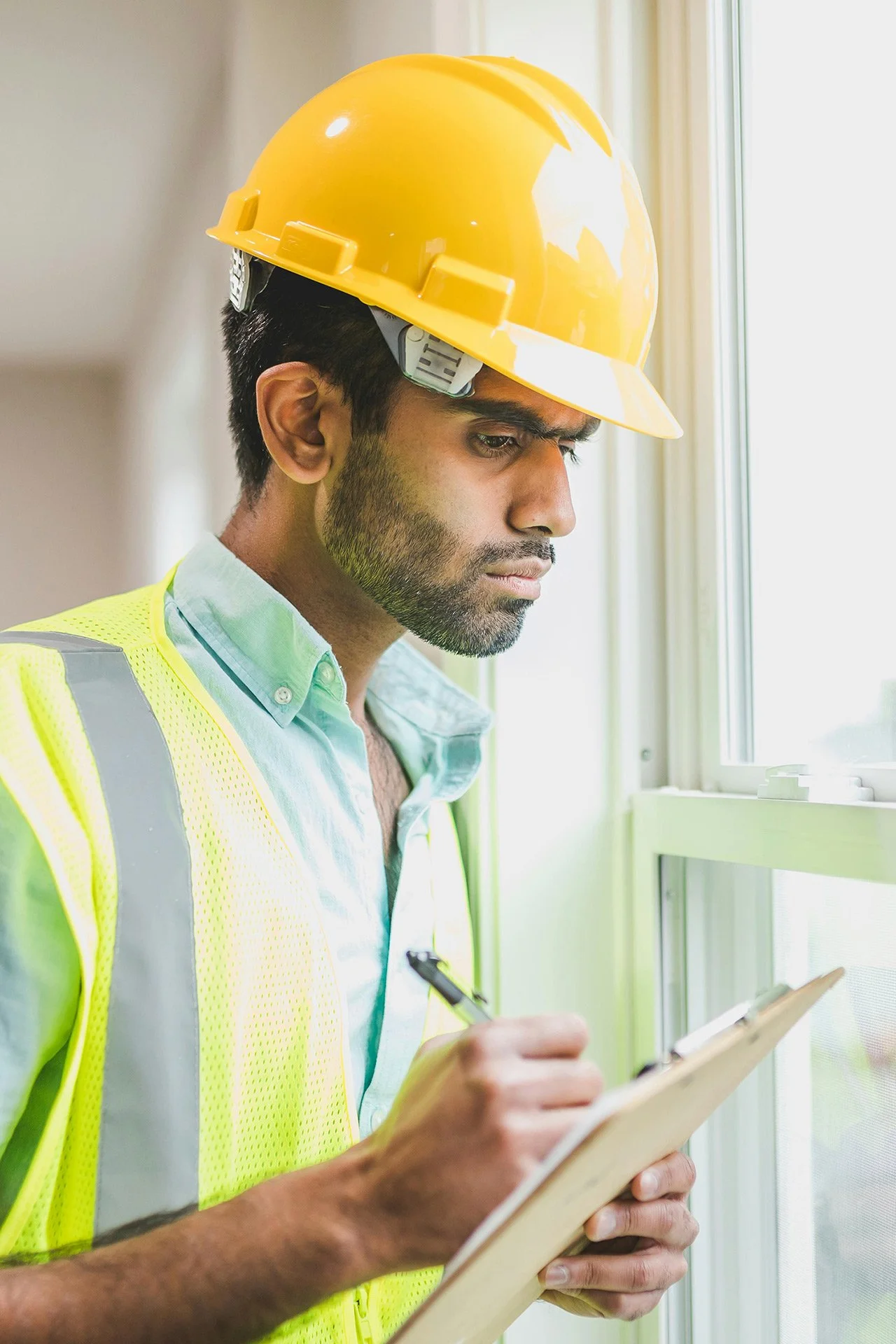 A male operative holding a clipboard and pen | Facilities Operations Software