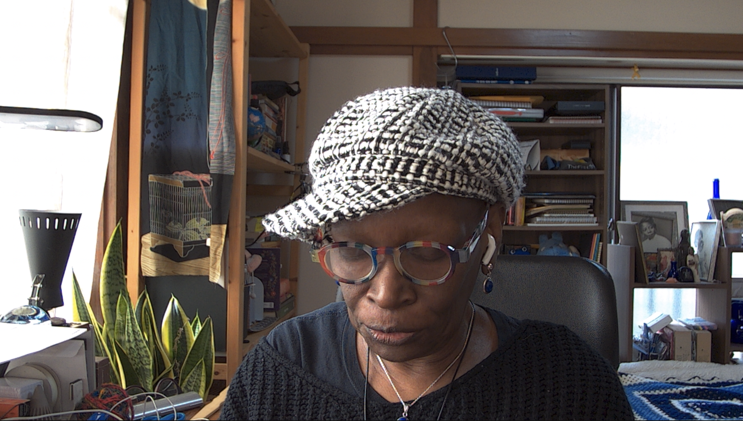 Terri in checked cap reading a book