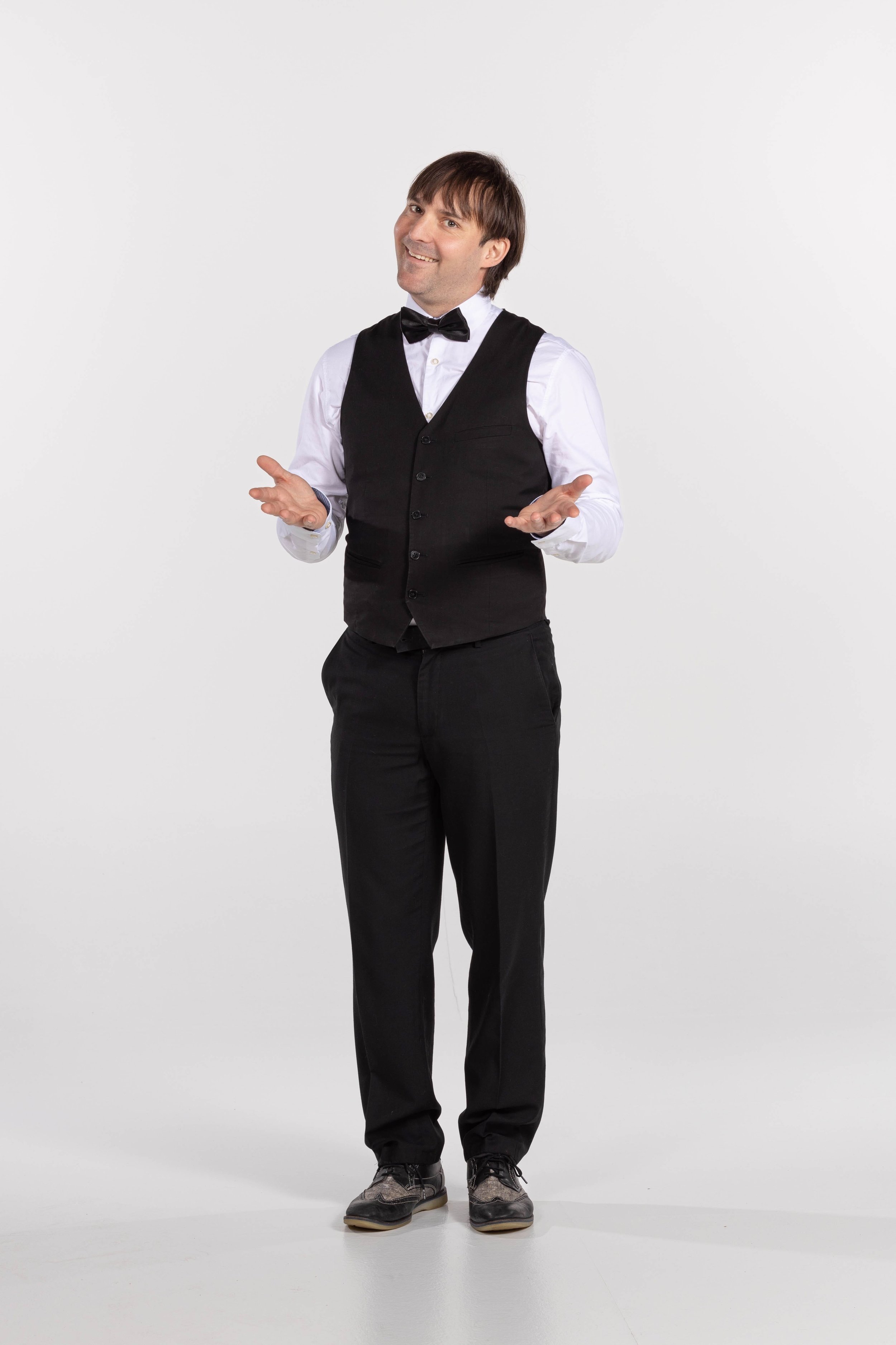 Cameriere comico in abbigliamento formale con gilet e papillon, sfondo bianco.