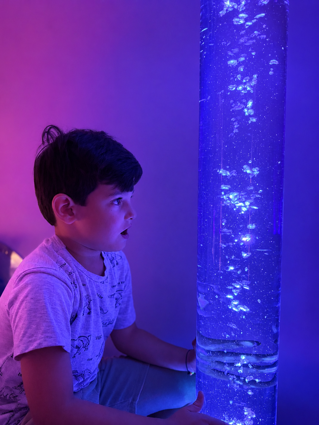 Un enfant est émerveillé devant la colonne à bulles