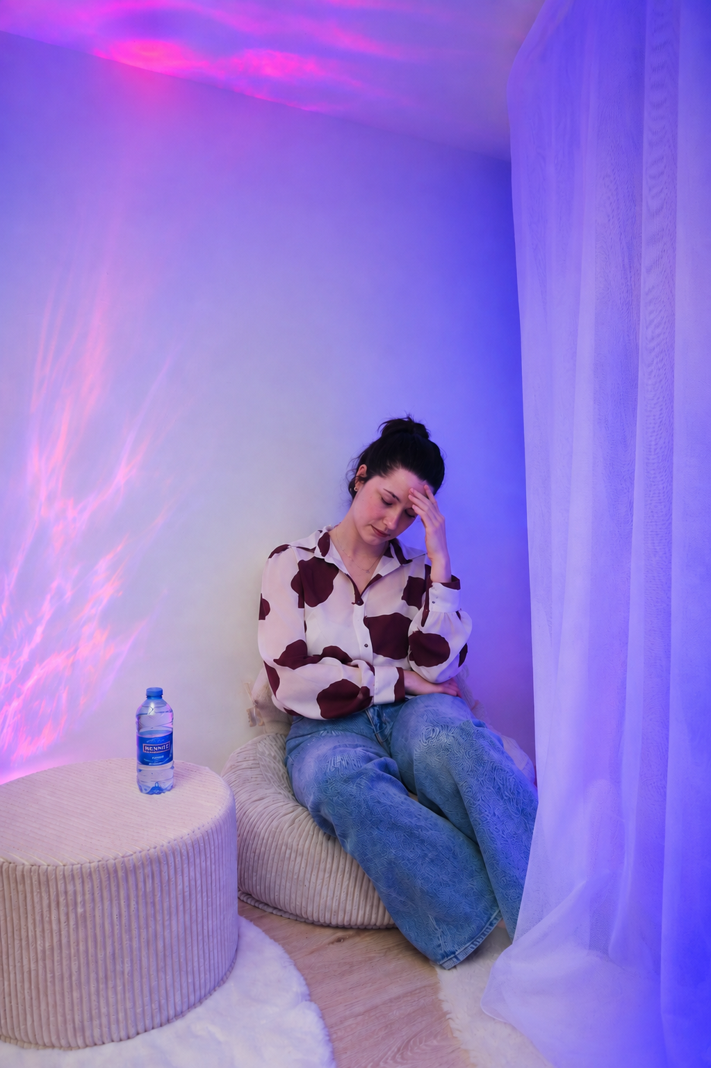 Une femme est fatiguée et stressée. Elle est posée sur un fauteuil de l'espace Snoezelen