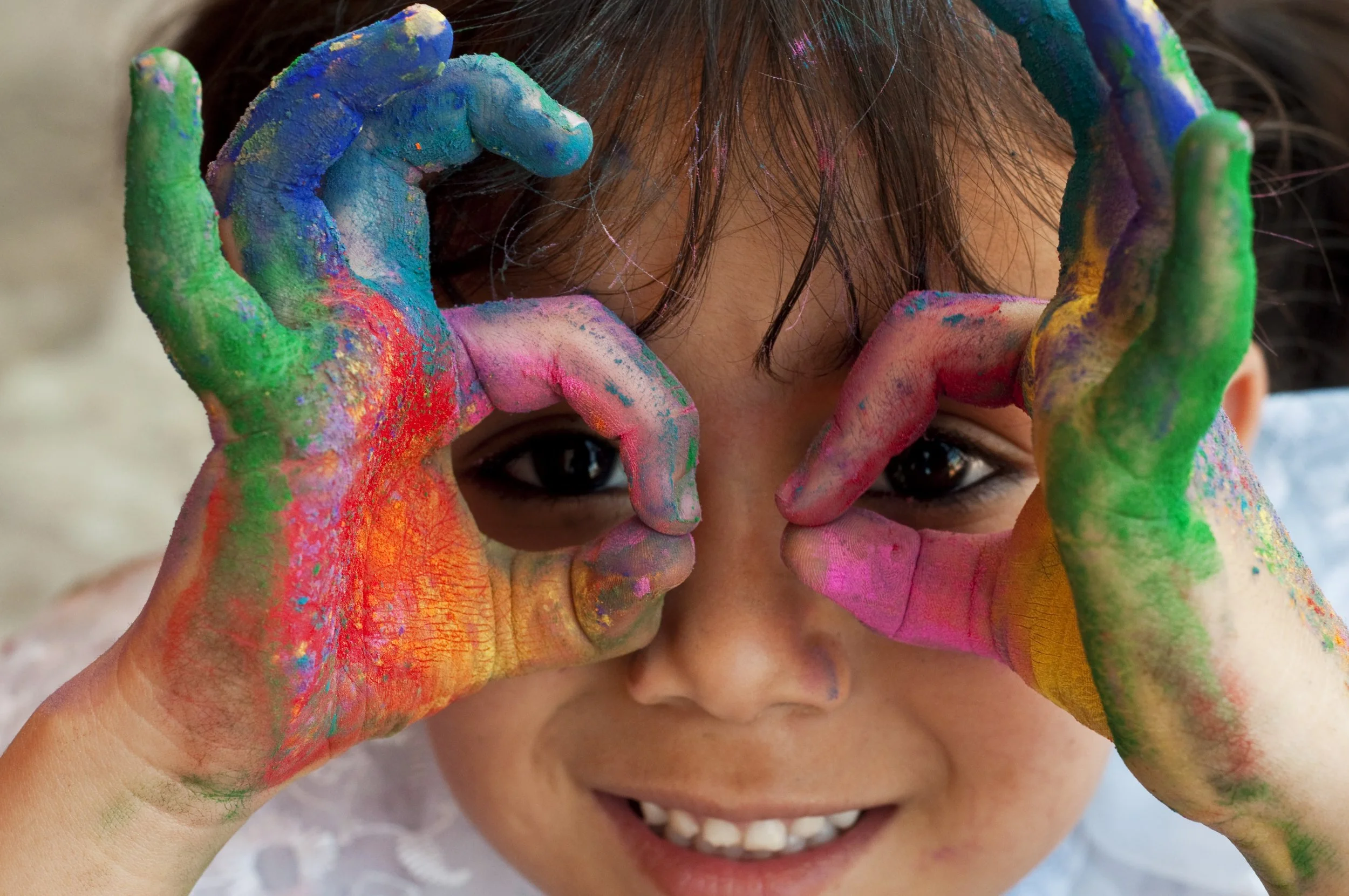 three year old happy at daycare center playing with arts and crafts