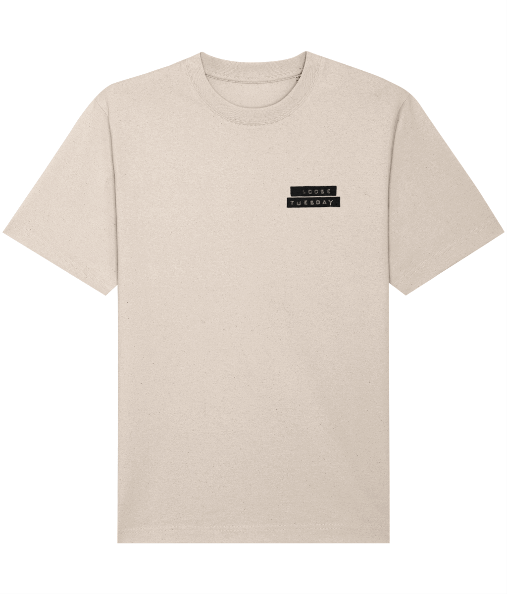 Loose Tuesday Label Tee — front view, small chest label mark on cream