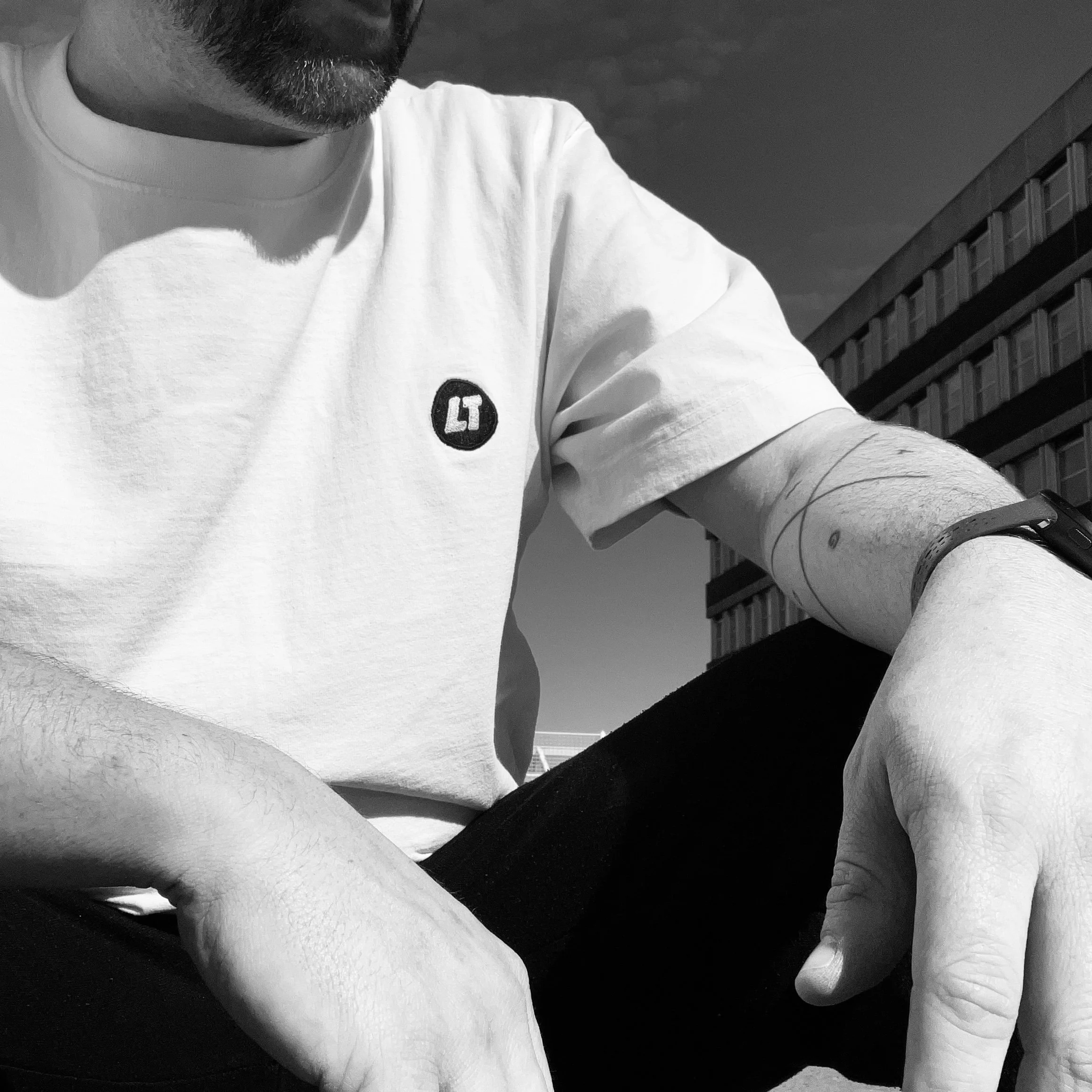 Loose Tuesday Logo Tee — chest mark detail, worn on model, black and white