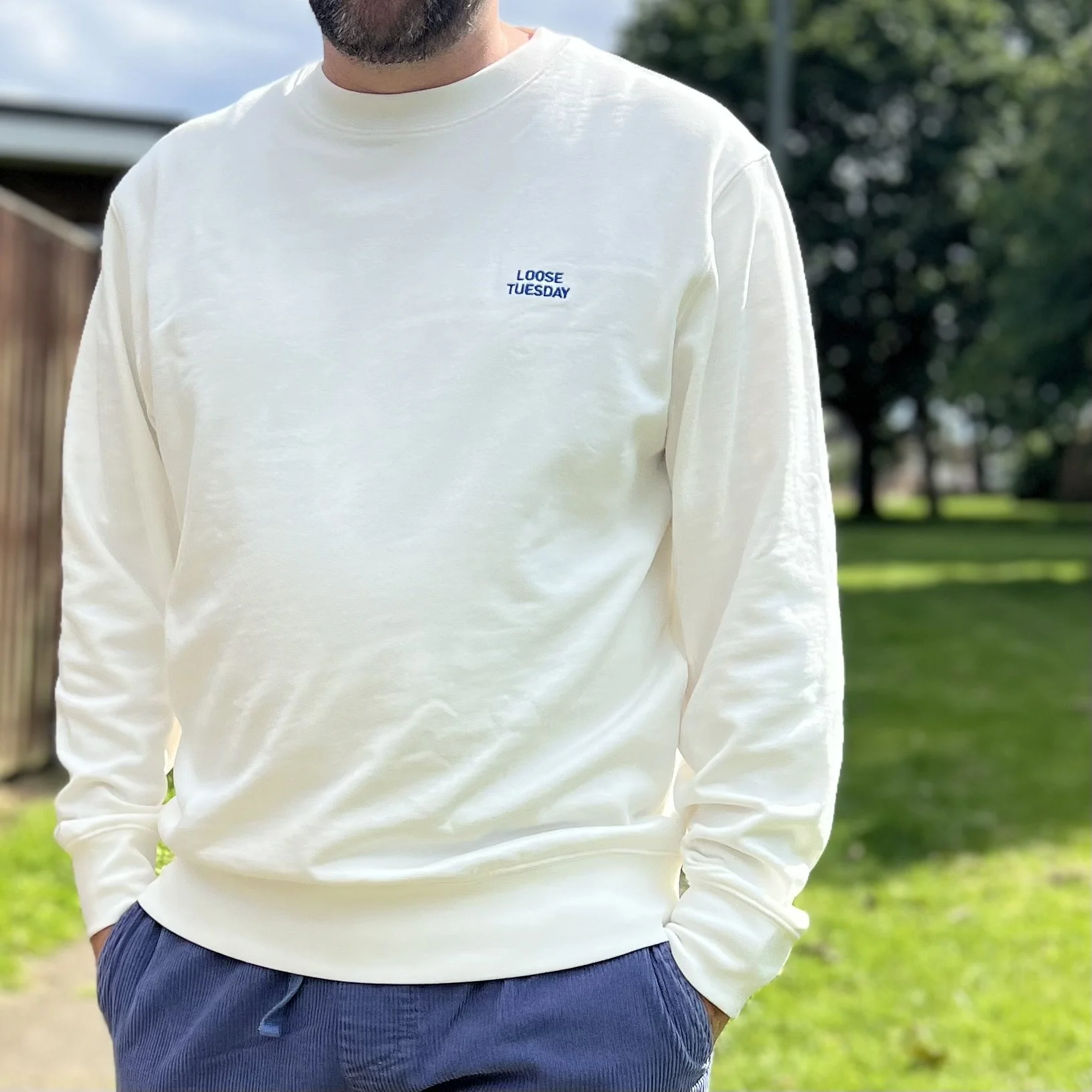 Model wearing loose tuesday headland sweater showing embroidered front logo