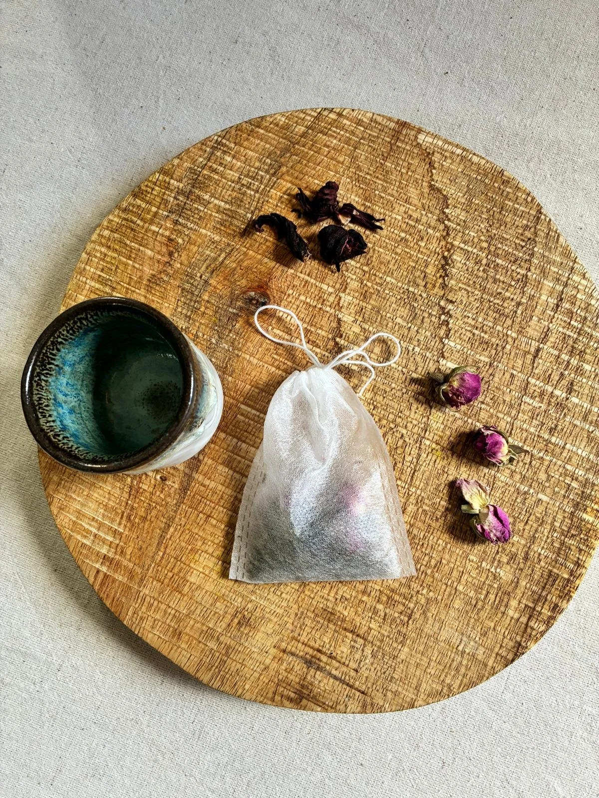Une tasse et un sachet de tisane ayurvédique (menthe, hibiscus et rose)