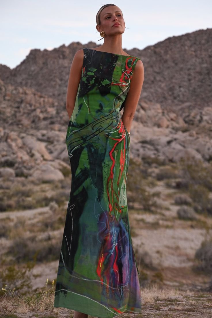 Woman in colorful abstract dress standing in desert landscape
