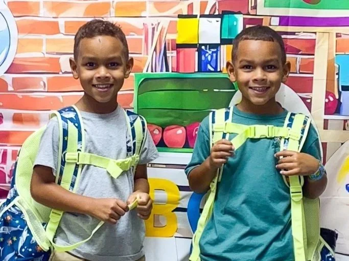 Two boys with new backpacks ready for school at Little Blessings