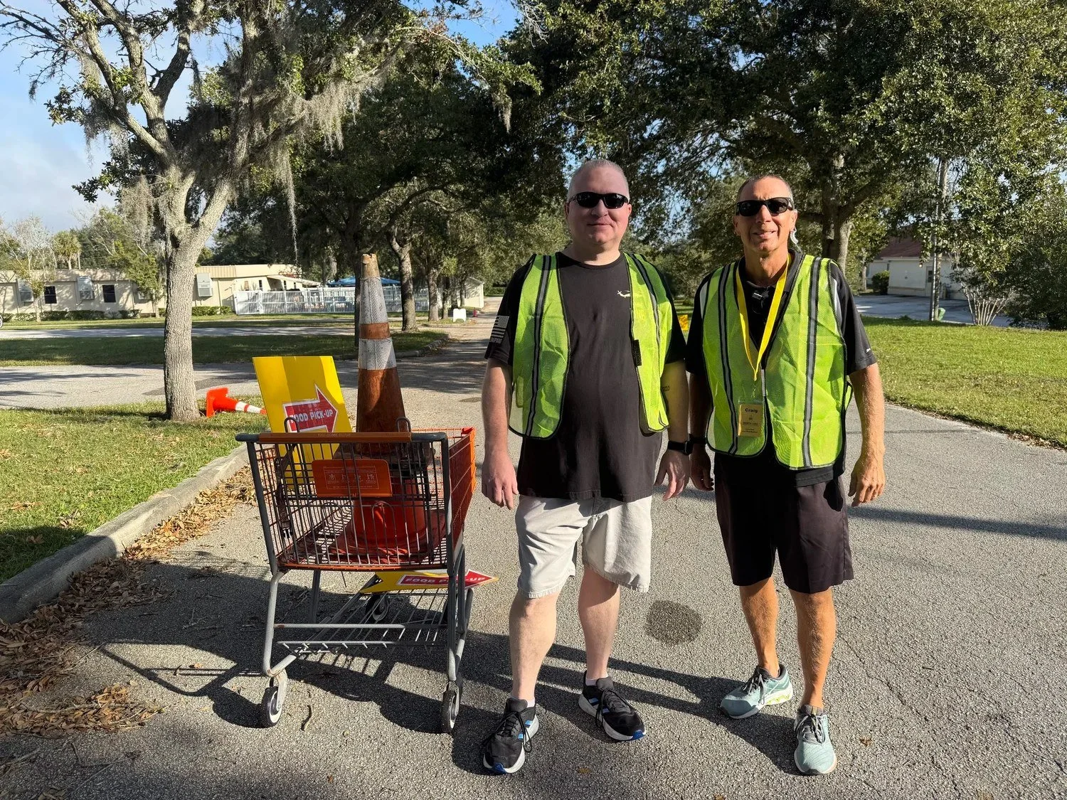 Two North Lake volunteers in safety vests at a community food distribution