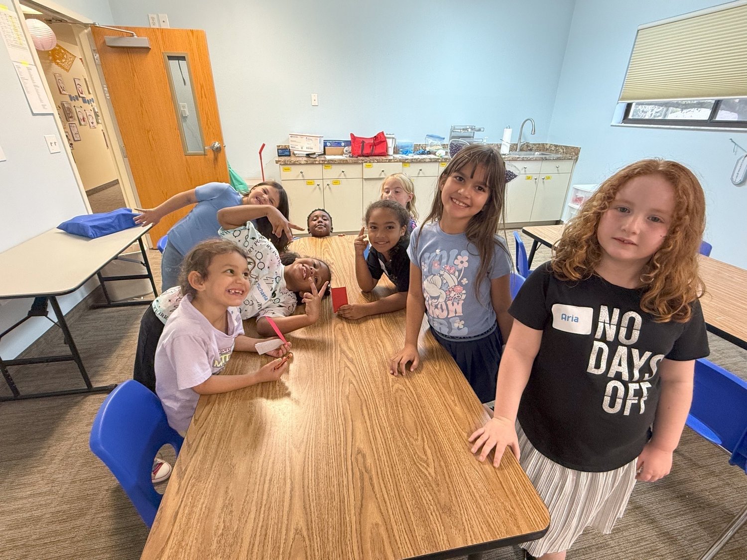 Smiling children gathered around a table at North Lake NOW