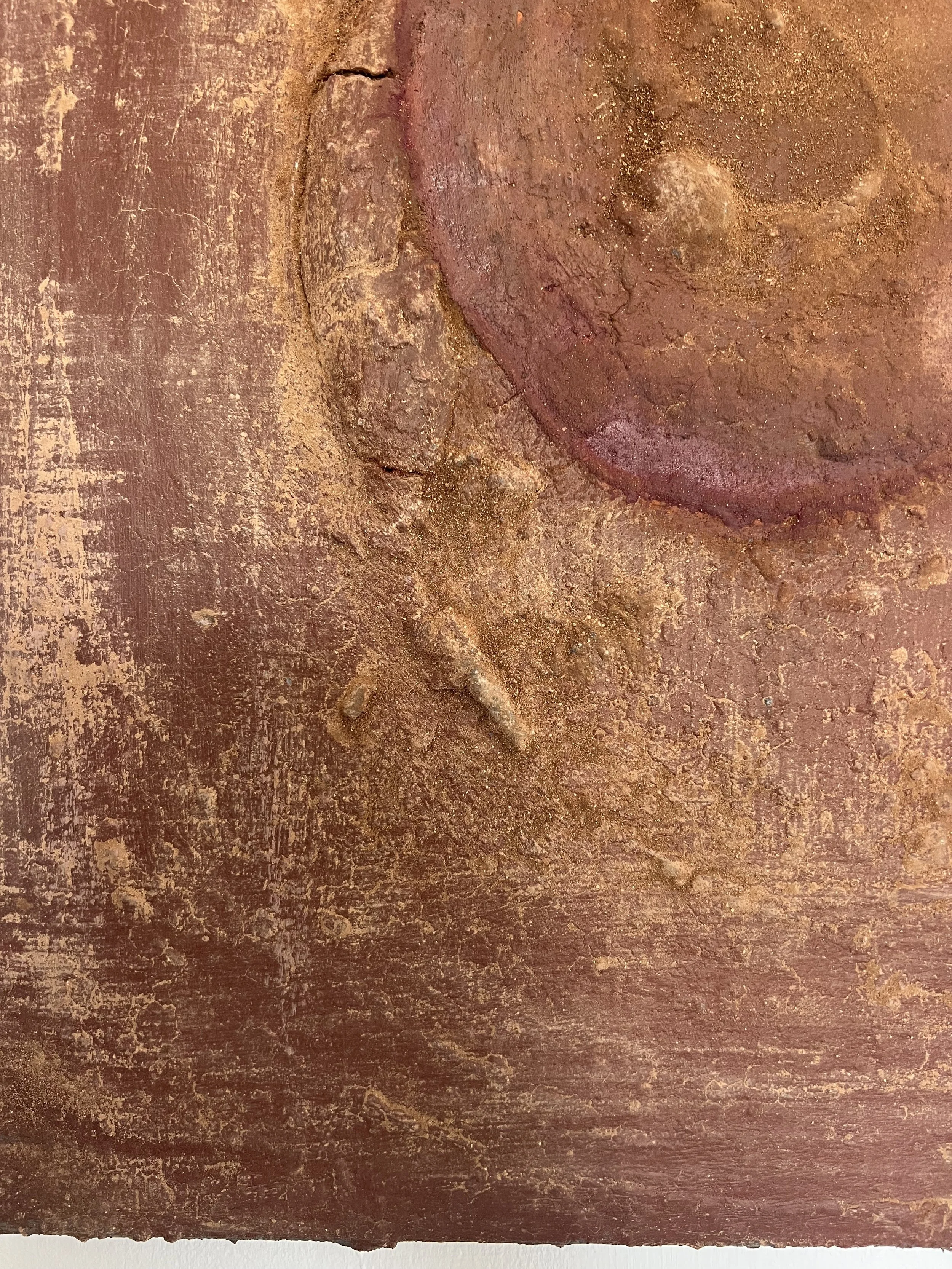 Close-up of a weathered reddish-brown textured surface with peeling paint, cracks, and exposed plaster
