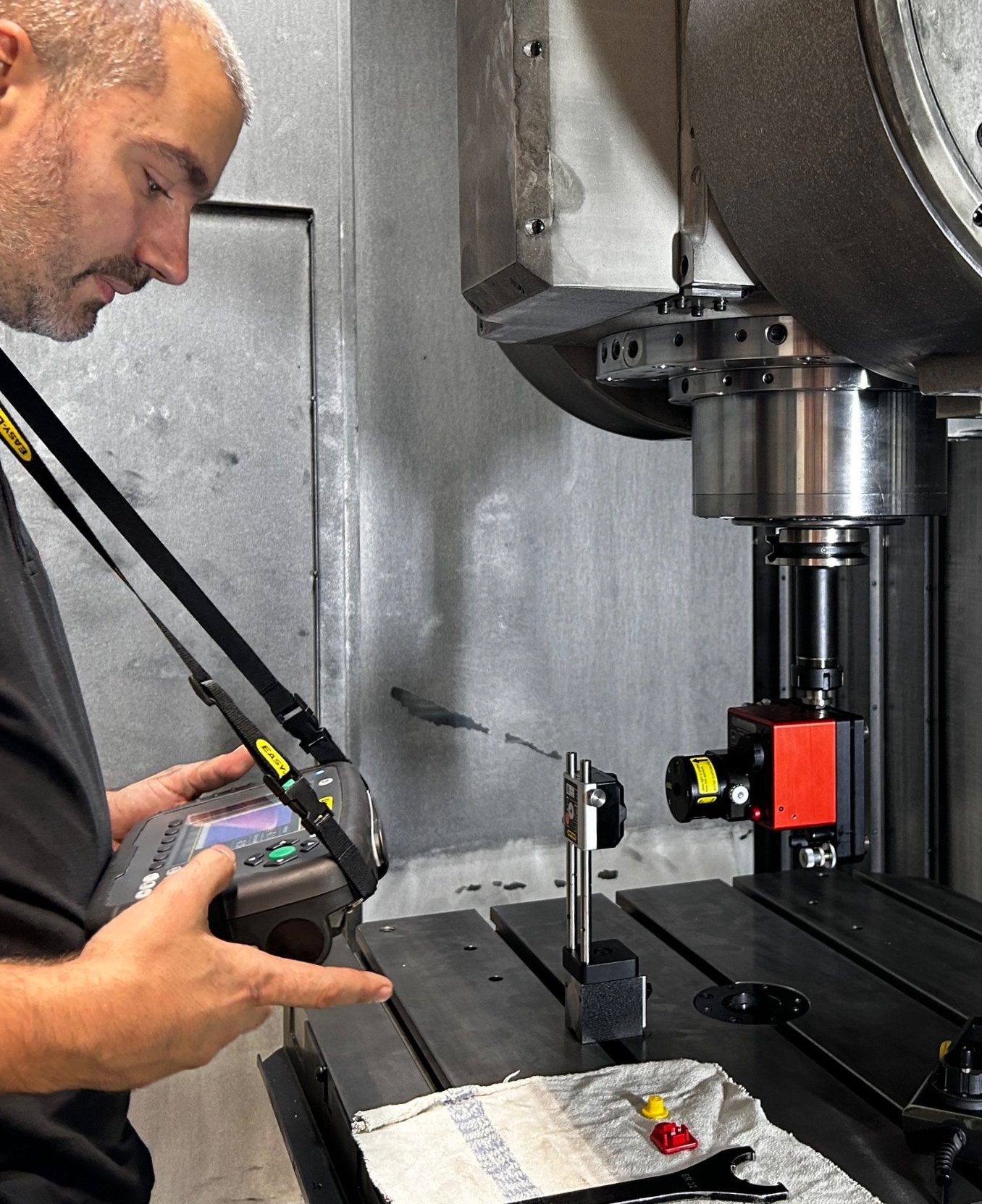 A man operating a coordinate measuring machine in an industrial setting.