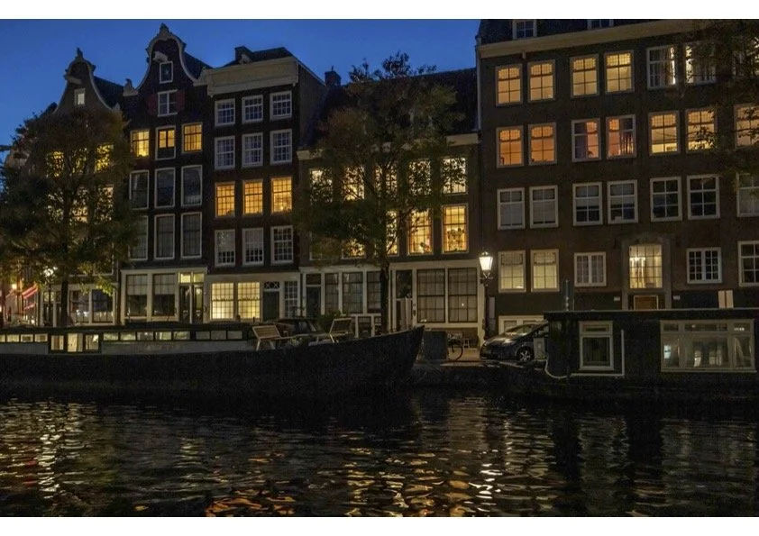 A traditional Amsterdam scene with gabled houses at dusk