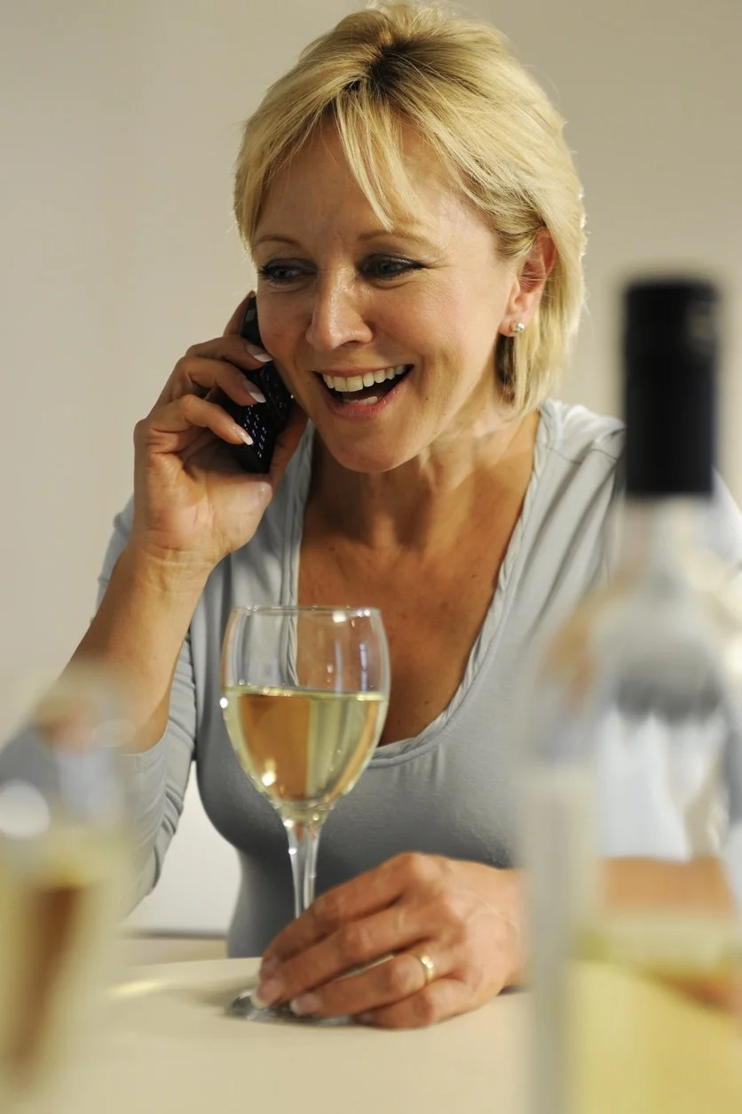 Louisa Hedley with a glass of wine whilst talking on her mobile