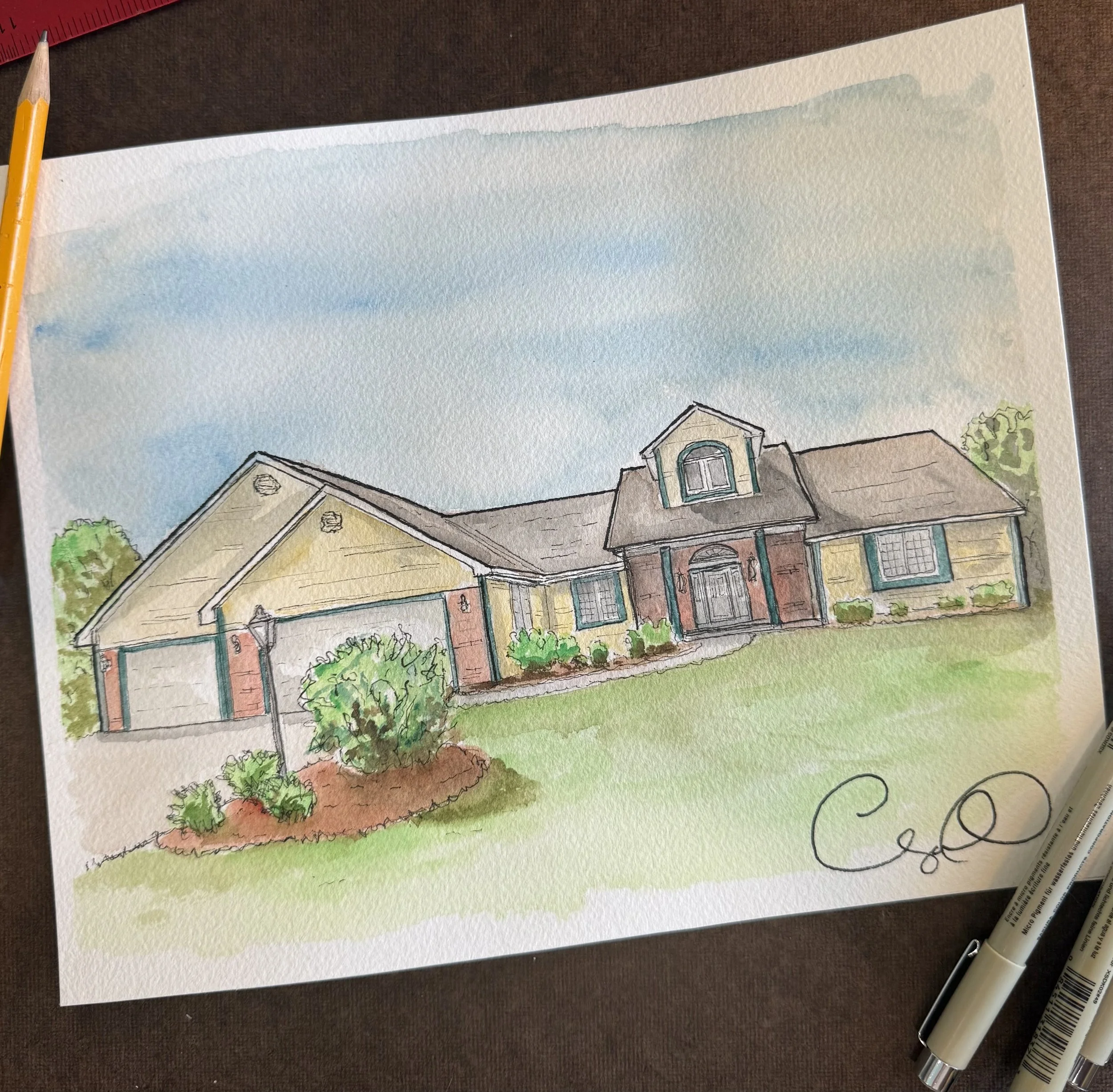 A watercolor painting of a row of houses with trees and bushes in the foreground. The houses have various colors and architectural features, and the sky behind them is painted with light blue and gray watercolor strokes.