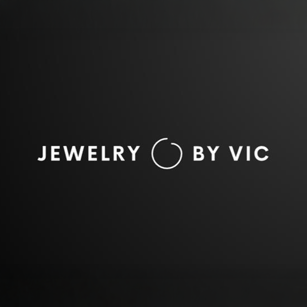 Logotyp för Jewelry by Vic med en cirkel i mitten på svart bakgrund.