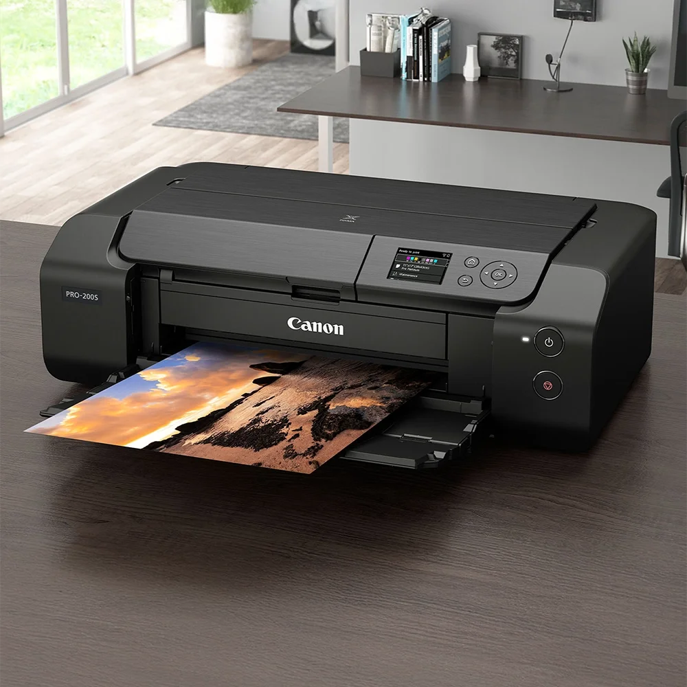 En bläckstråleskrivare skriver ut en färgbild av en solnedgång över ett landskap.