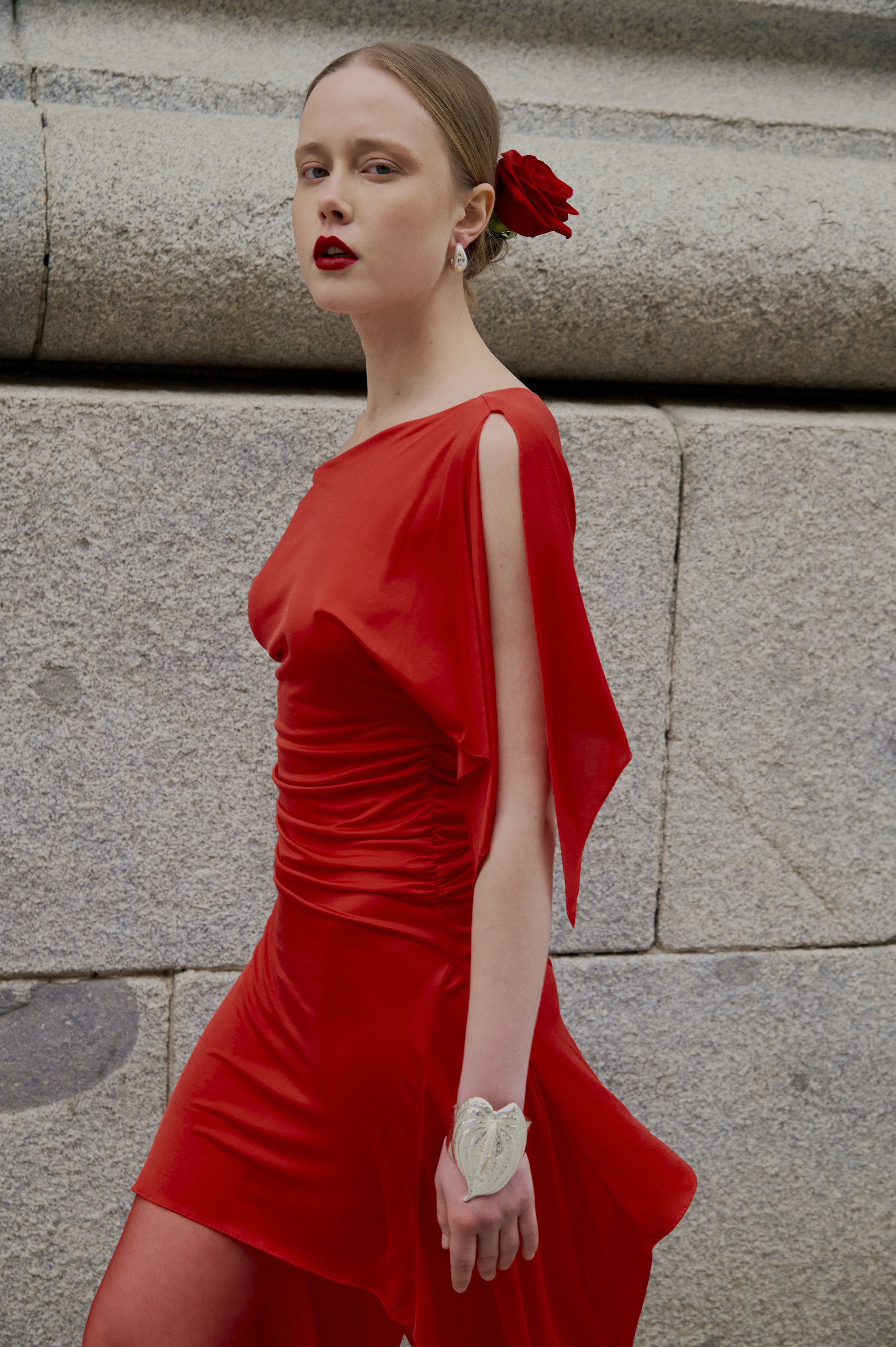 Couture red dress with fluid jersey draping and asymmetric sleeve detail