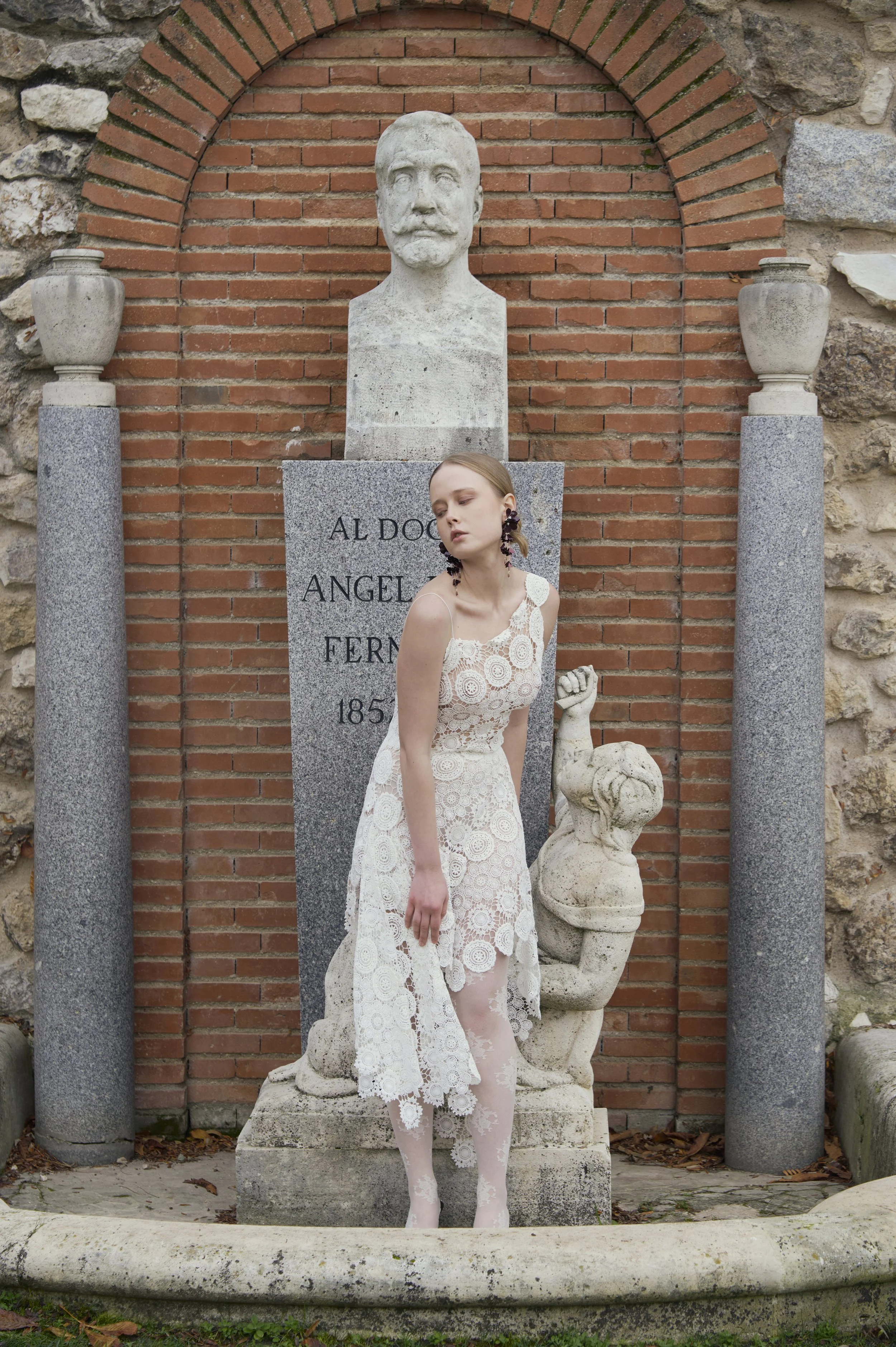 White crochet couture dress with sculptural circular appliqués and open-back design