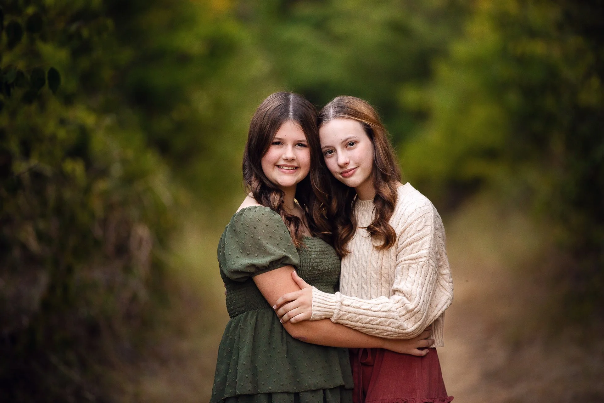 Beautiful-color-photo-of-two-sisters-hugging-in-a-green-field.jpg