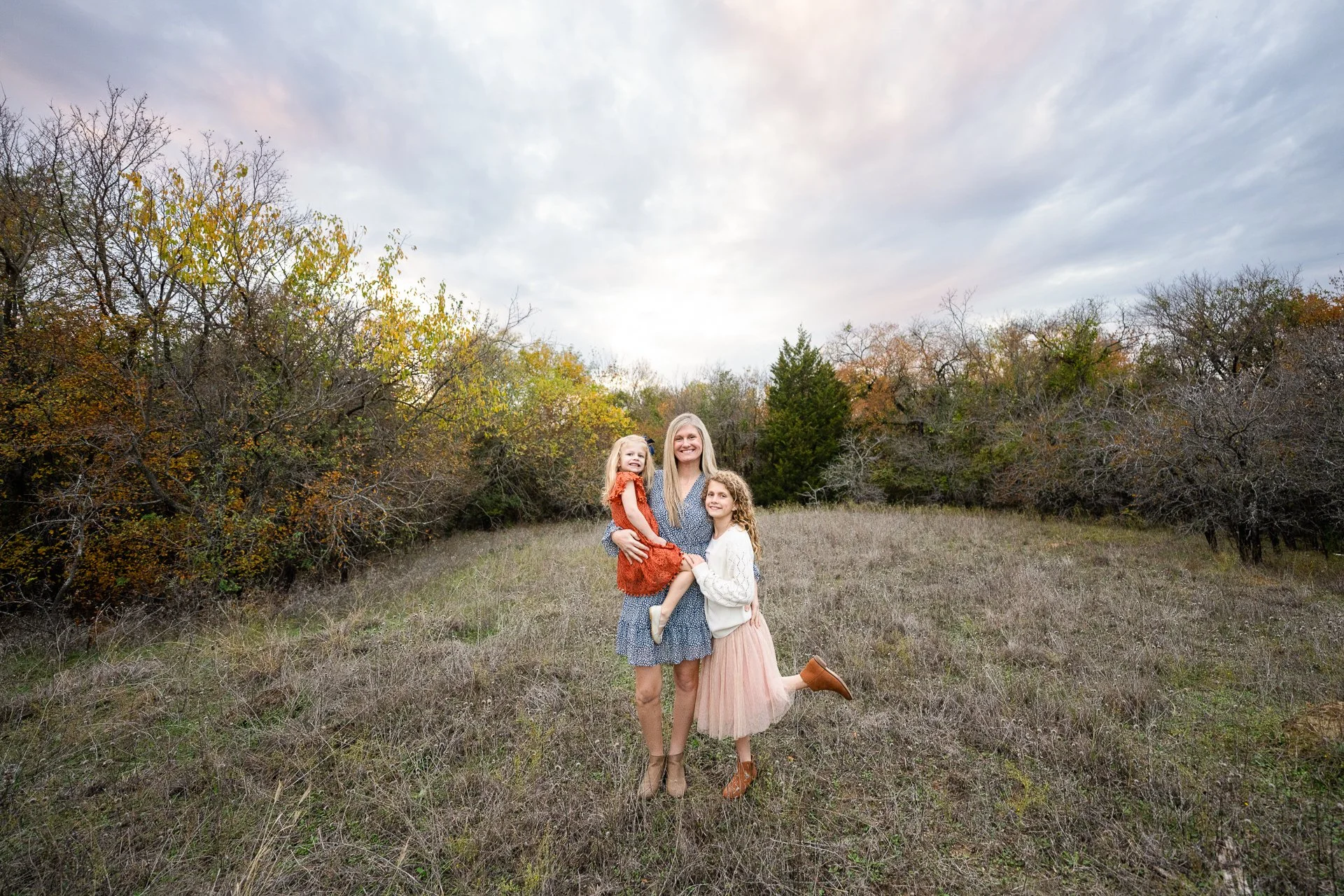 Colorful-image-of-a-mother-and-two-daughters-standing-in-a-field-during-a-family-lifestyle-shoot-near-Southlake-Texas.jpg