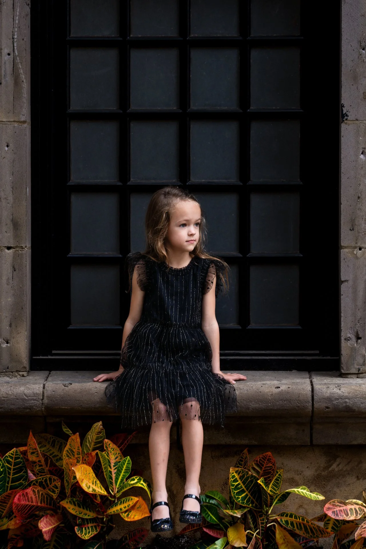 Color-portrait-of-a-little-girl-sitting-on-a-window-sill-in-Dallas-Texas.jpg