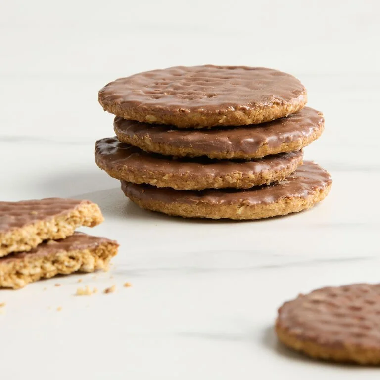Stack of four chocolate-covered oatmeal cookies with one cookie broken in front.