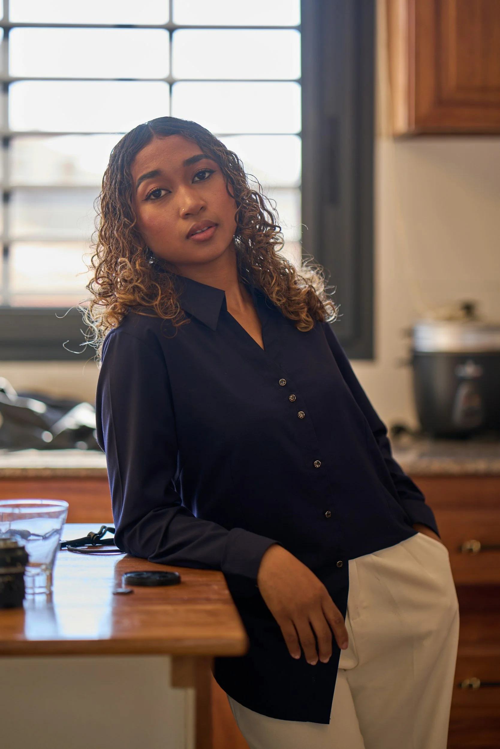 A woman journaling at her kitchen table, taking her first steps toward financial recovery after leaving an abusive relationship.