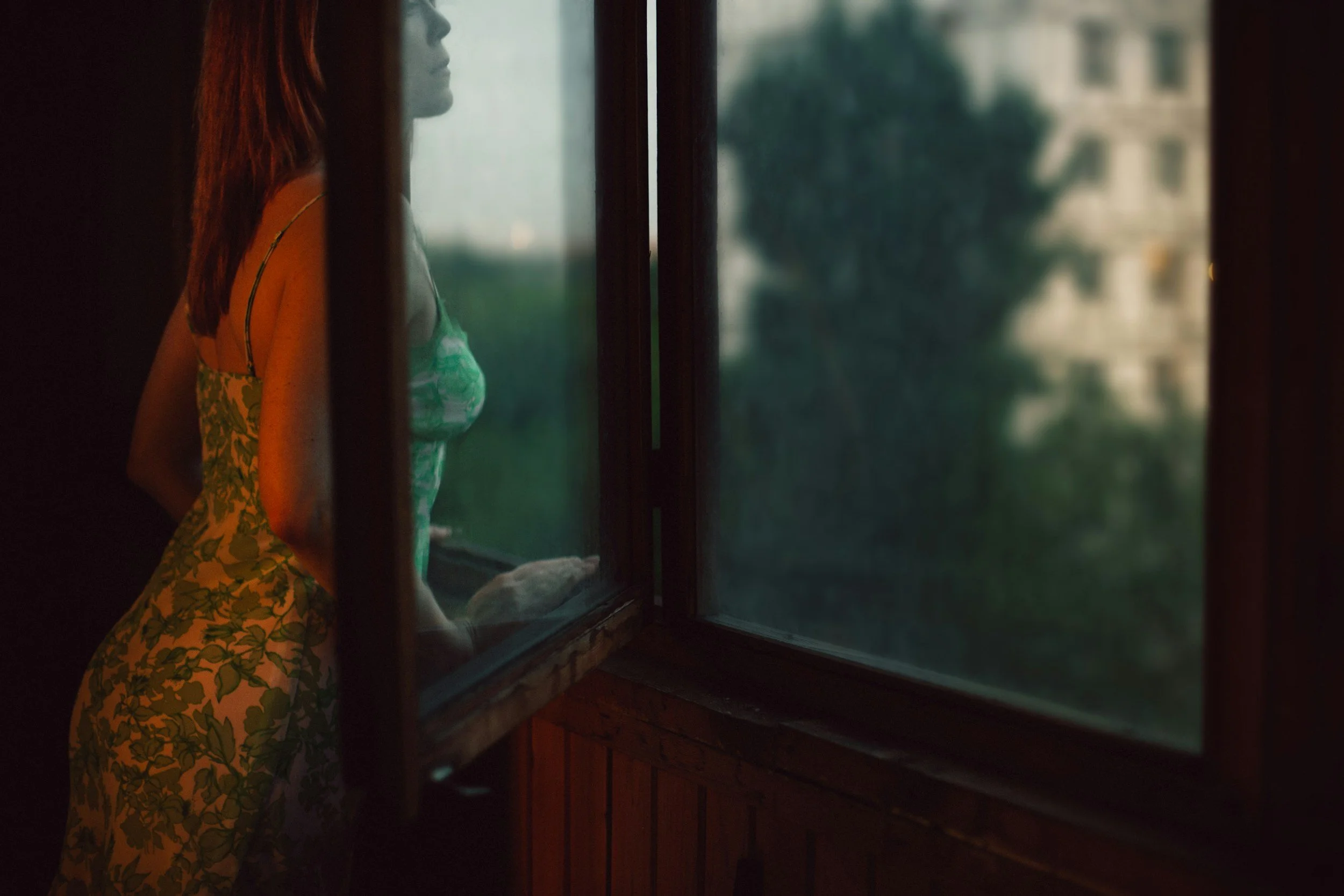 A trauma survivor standing in soft light, reflecting on her identity and healing journey.
