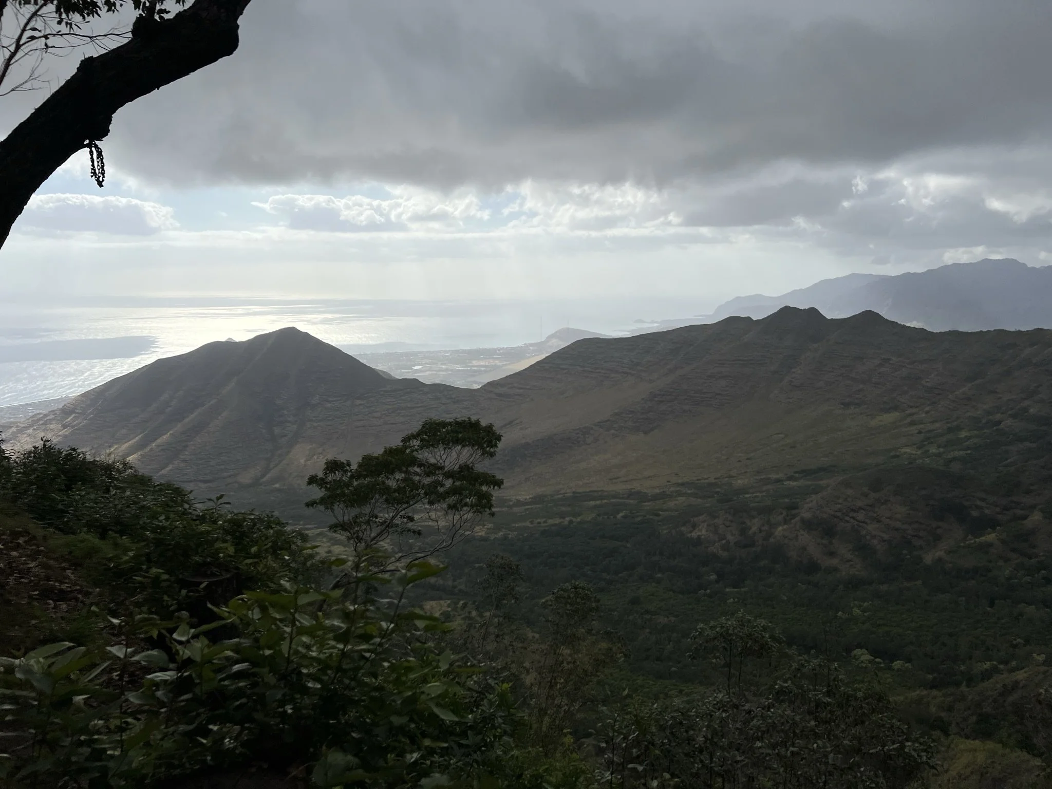Scenic mountain landscape with lush greenery and hills under a cloudy sky. Hawaii film, video, photo production service