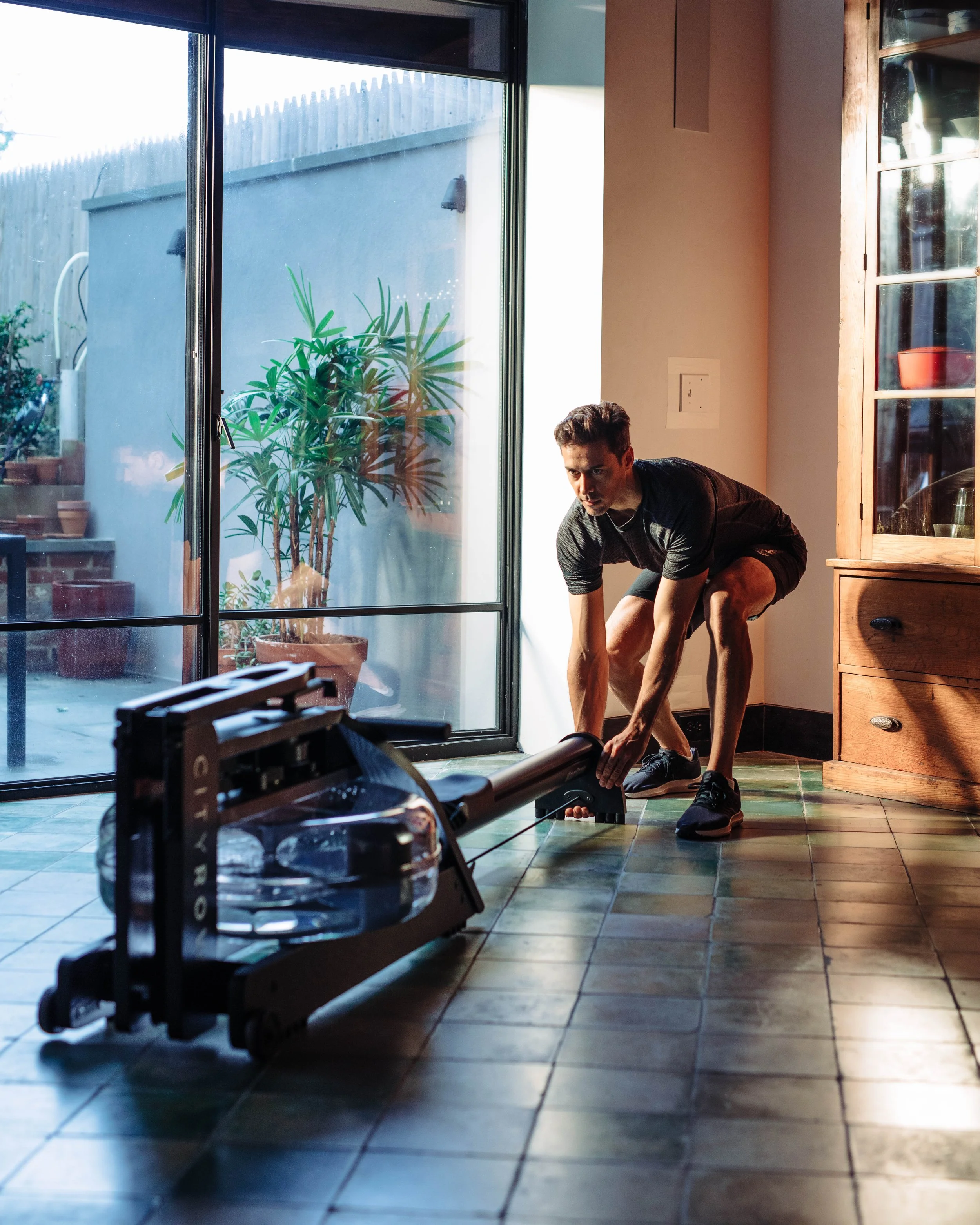 Male taking out rower in living room