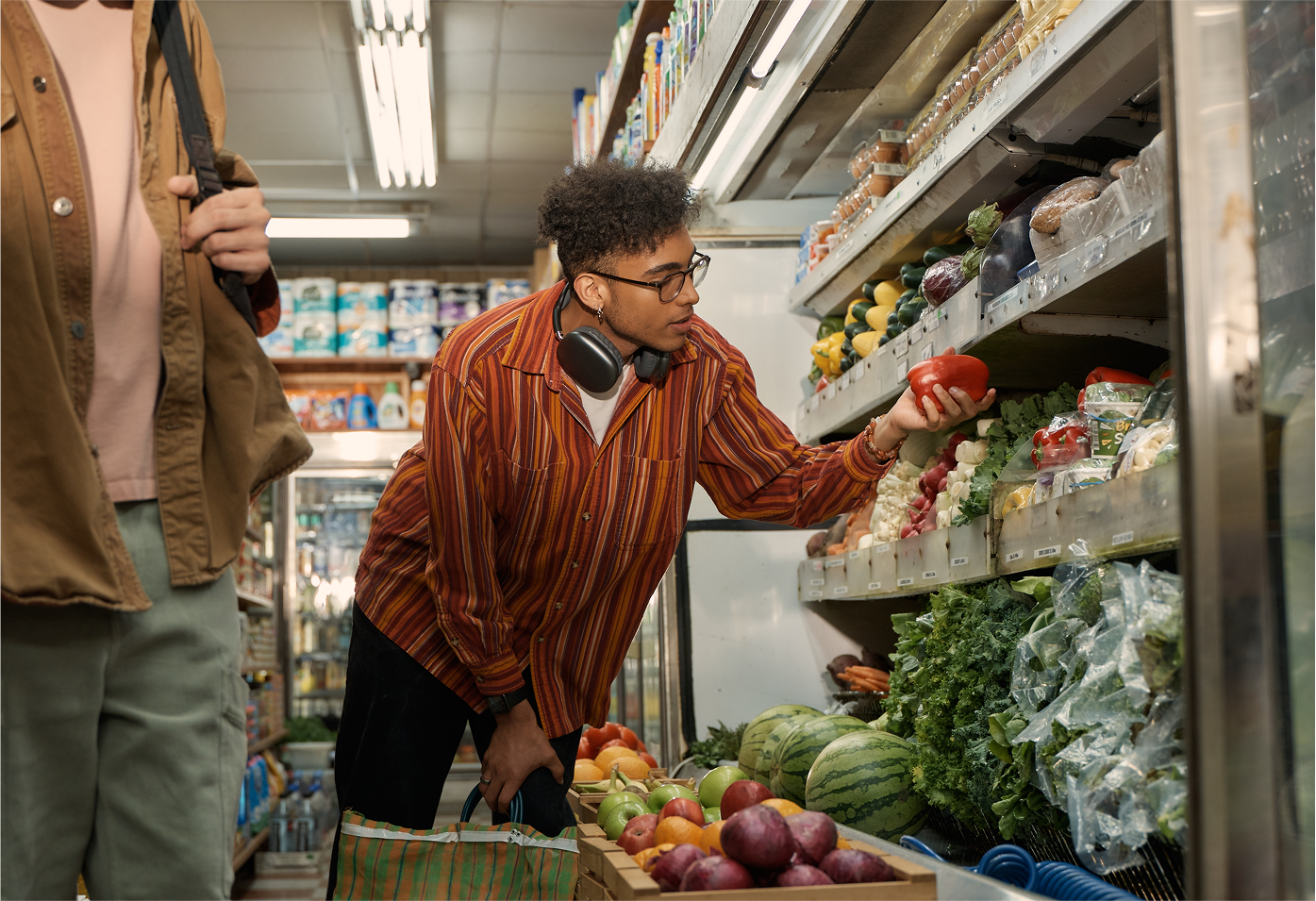 Young male adult picking out groceries in bodega