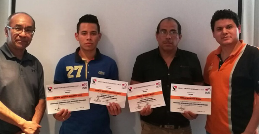 Cuatro hombres sosteniendo certificados de reconocimiento en un fondo de pared blanca.
