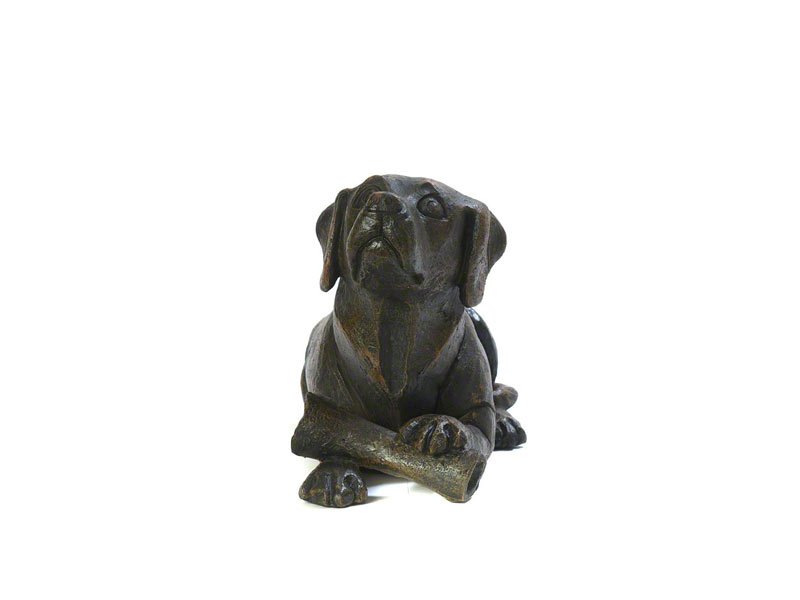 A cast resin Dog and Bone figurine urn, with a bronze finish, showcasing detailed features and a relaxed posture.