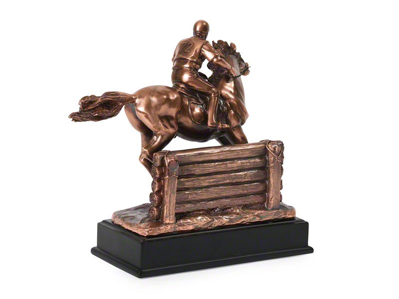A detailed copper plated statue of a jockey riding a horse, showcasing dynamic motion in front of a jump with a glossy black base.