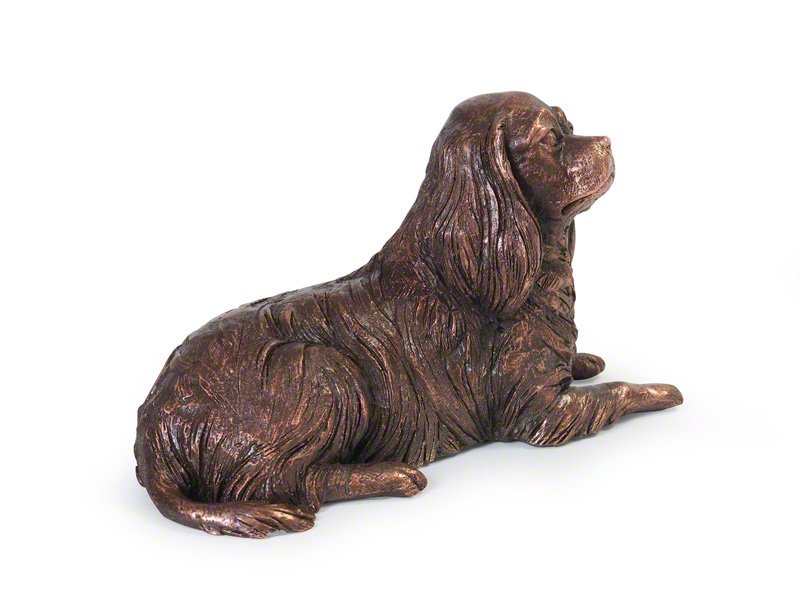 A copper plated sculpture of a resting Cavalier King Charles Spaniel with lifelike fur texture and expressive features, showcasing the artist's attention to detail.