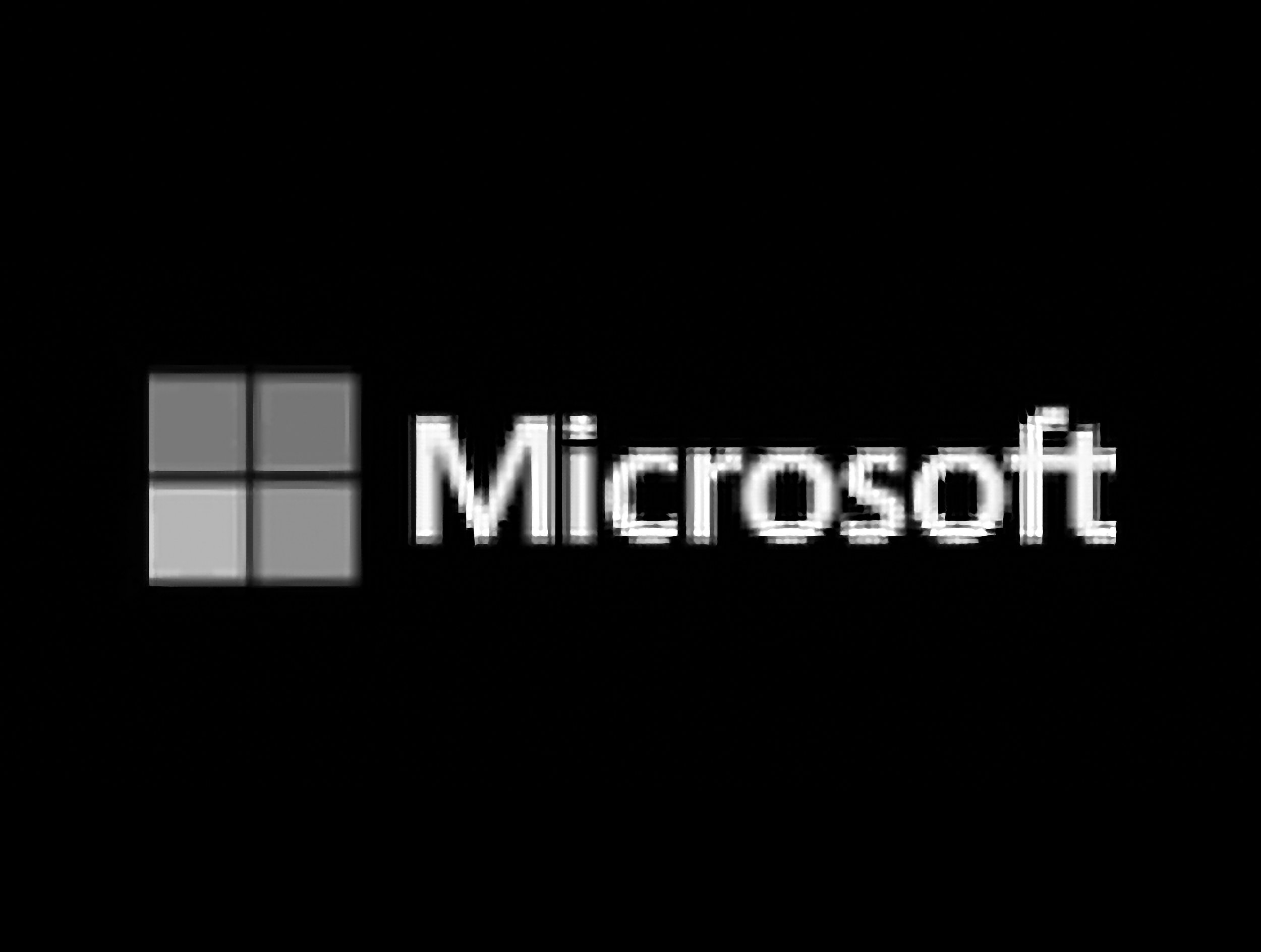 Microsoft logo with four gray squares and the word 'Microsoft' in white text.