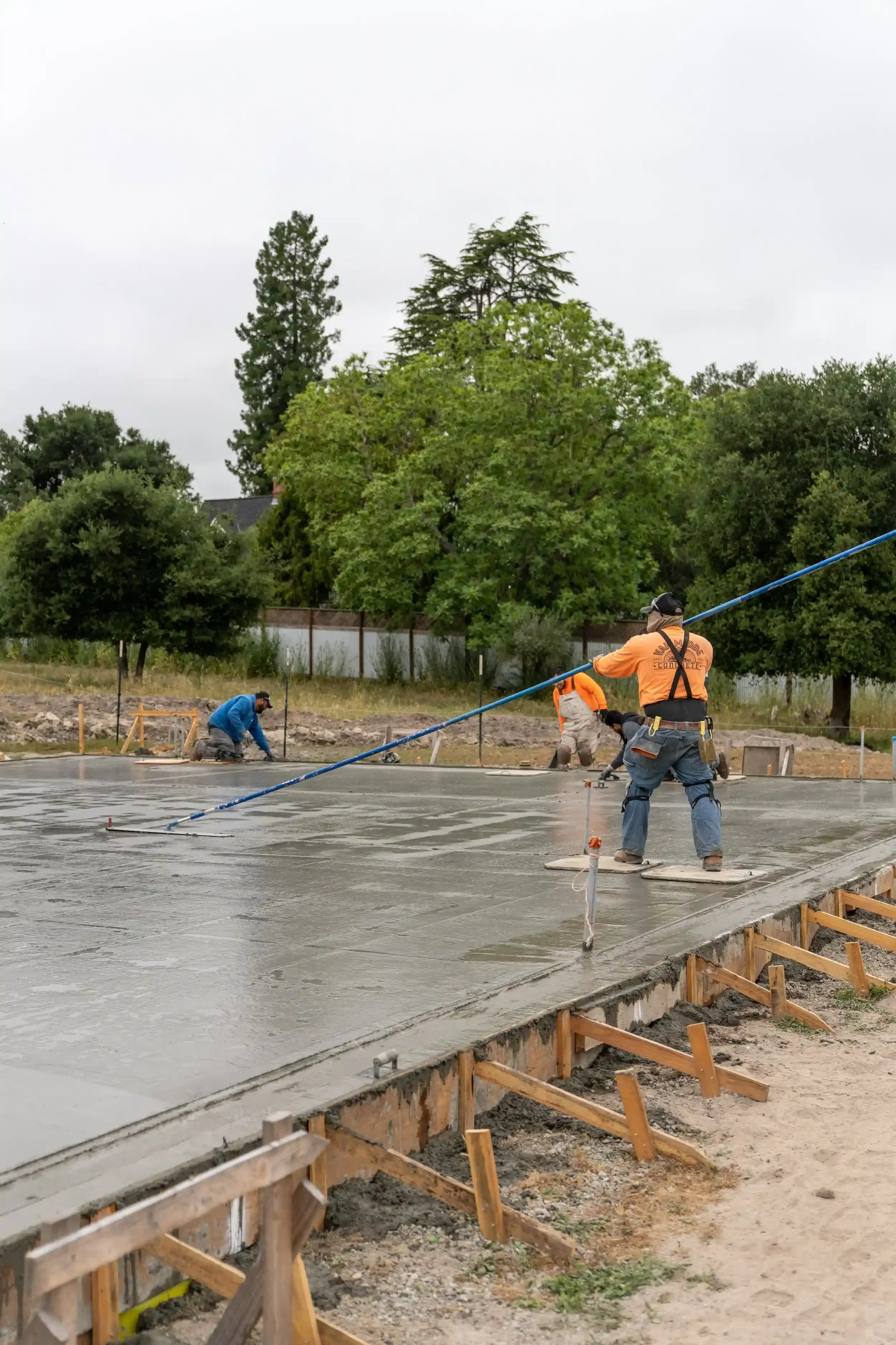a-man-is-spraying-water-on-a-flooded-street.webp