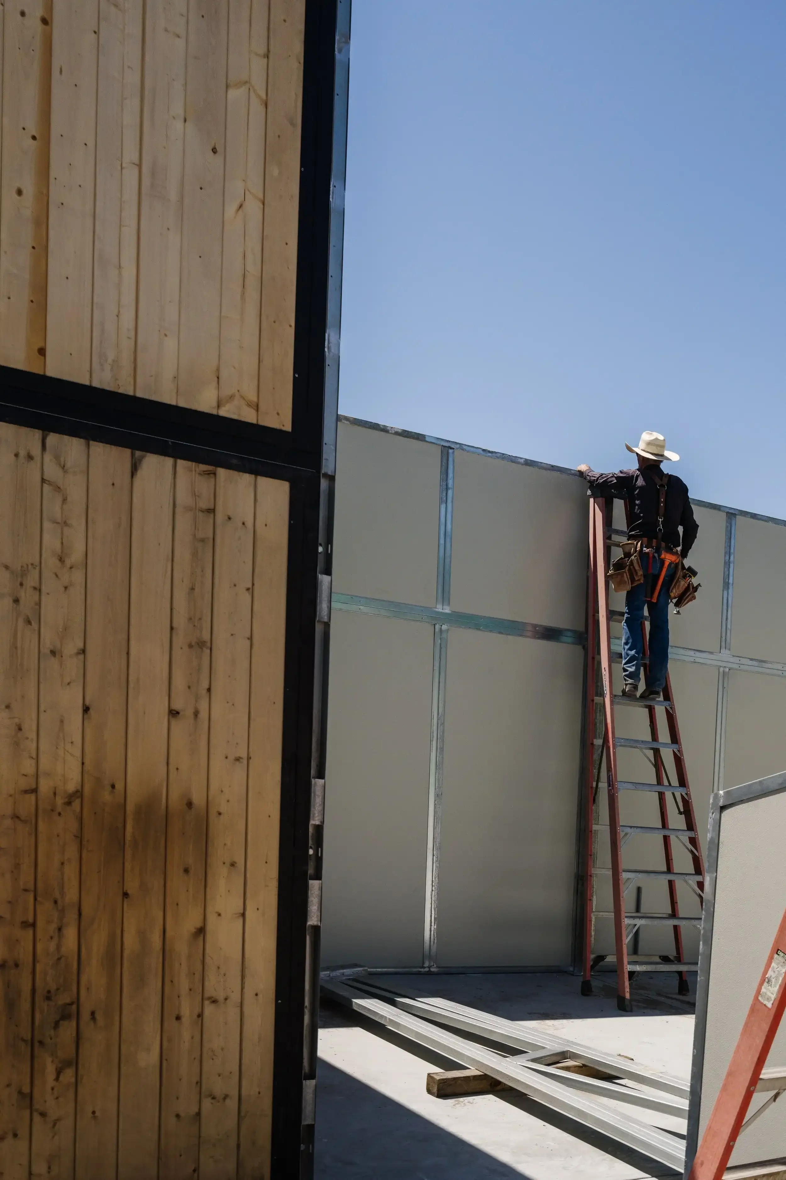 a-man-is-standing-on-a-ledge-near-a-building.webp