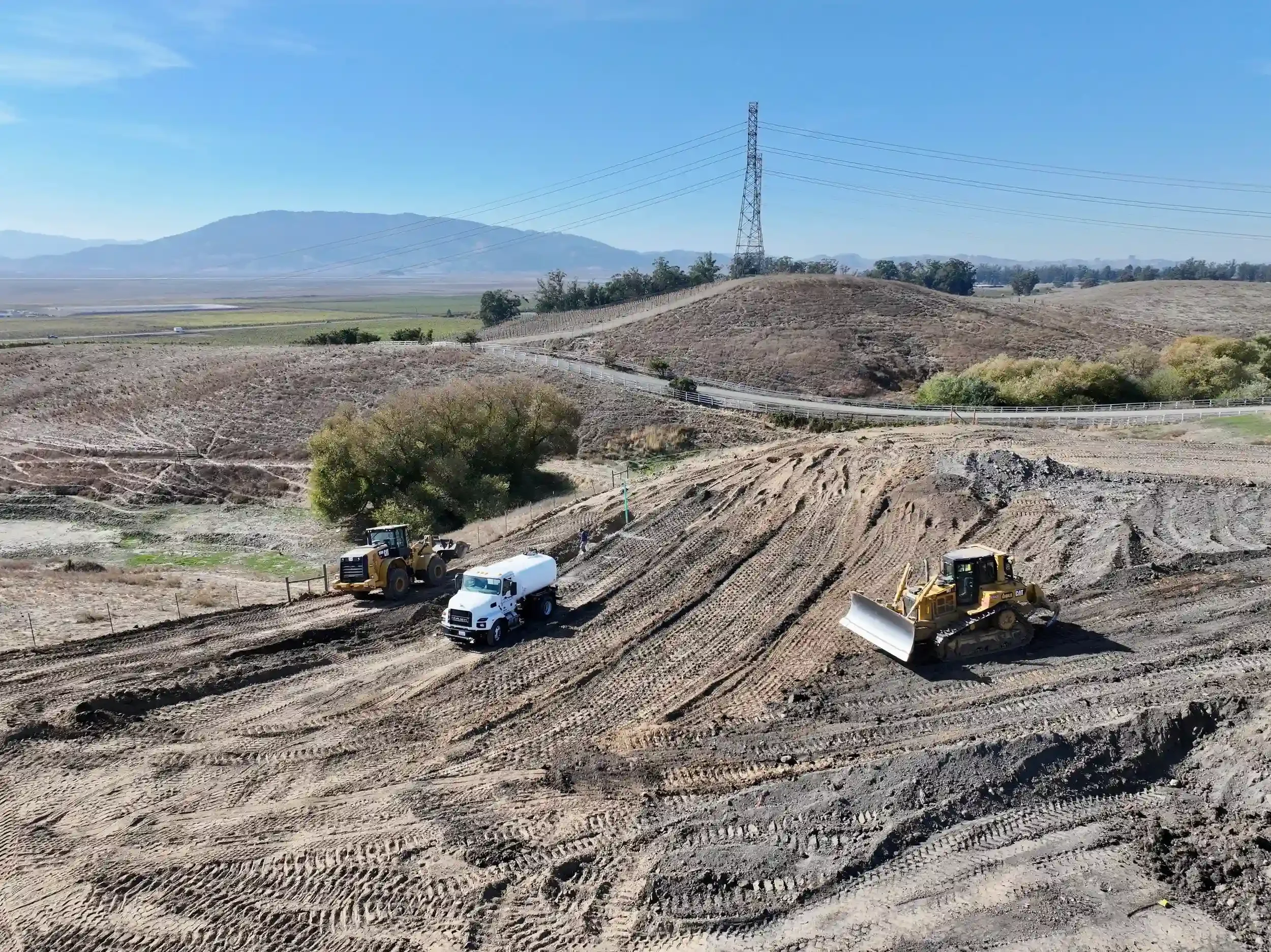 a-dirt-field-with-a-truck-and-a-bulldozer.webp