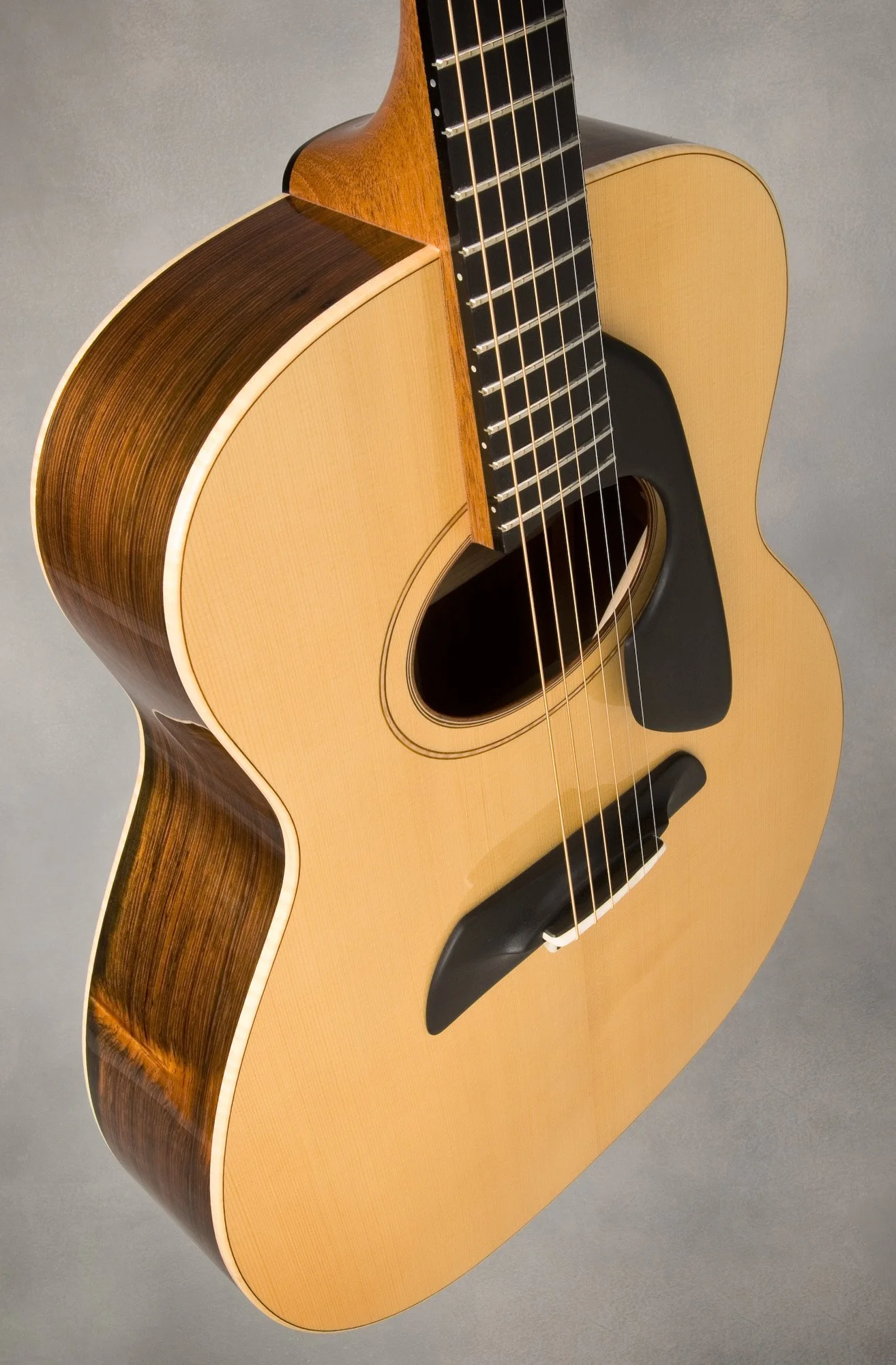 Acoustic guitar with light wood top and dark wood sides, angled view.