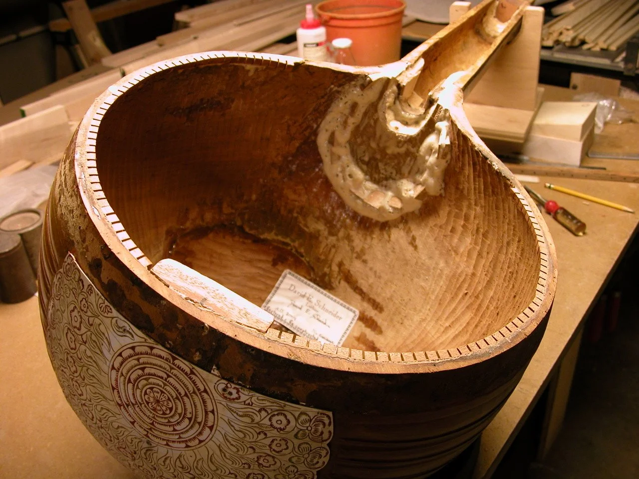 Unfinished wooden stringed instrument body in workshop